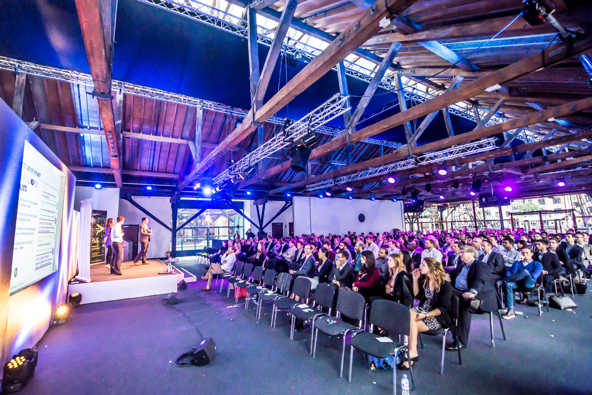 Corporate presentation in Tobacco Dock industrial venue with theater seating for event staging.