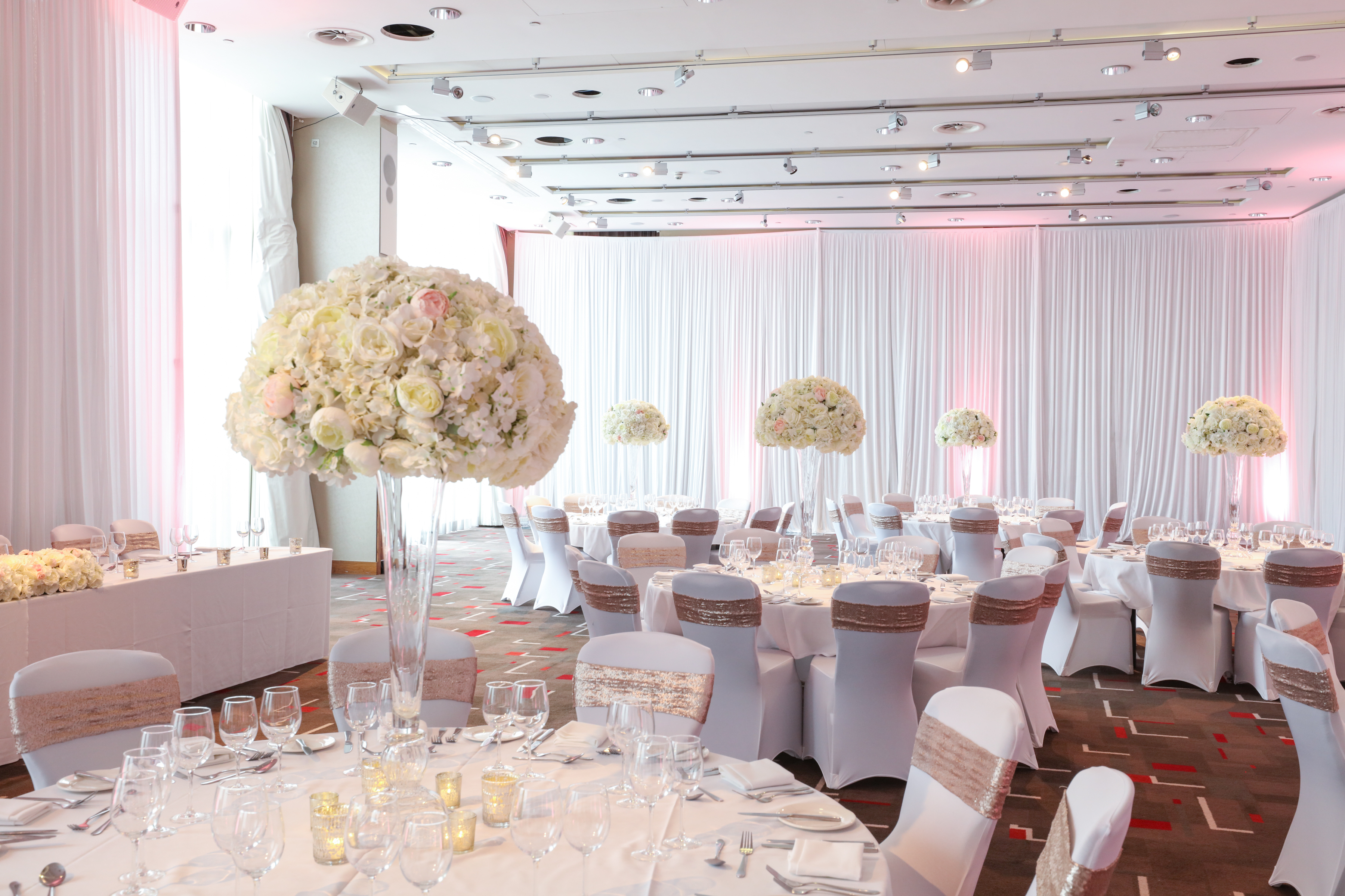 Elegant event space in Hilton Liverpool with floral centerpieces, perfect for weddings.