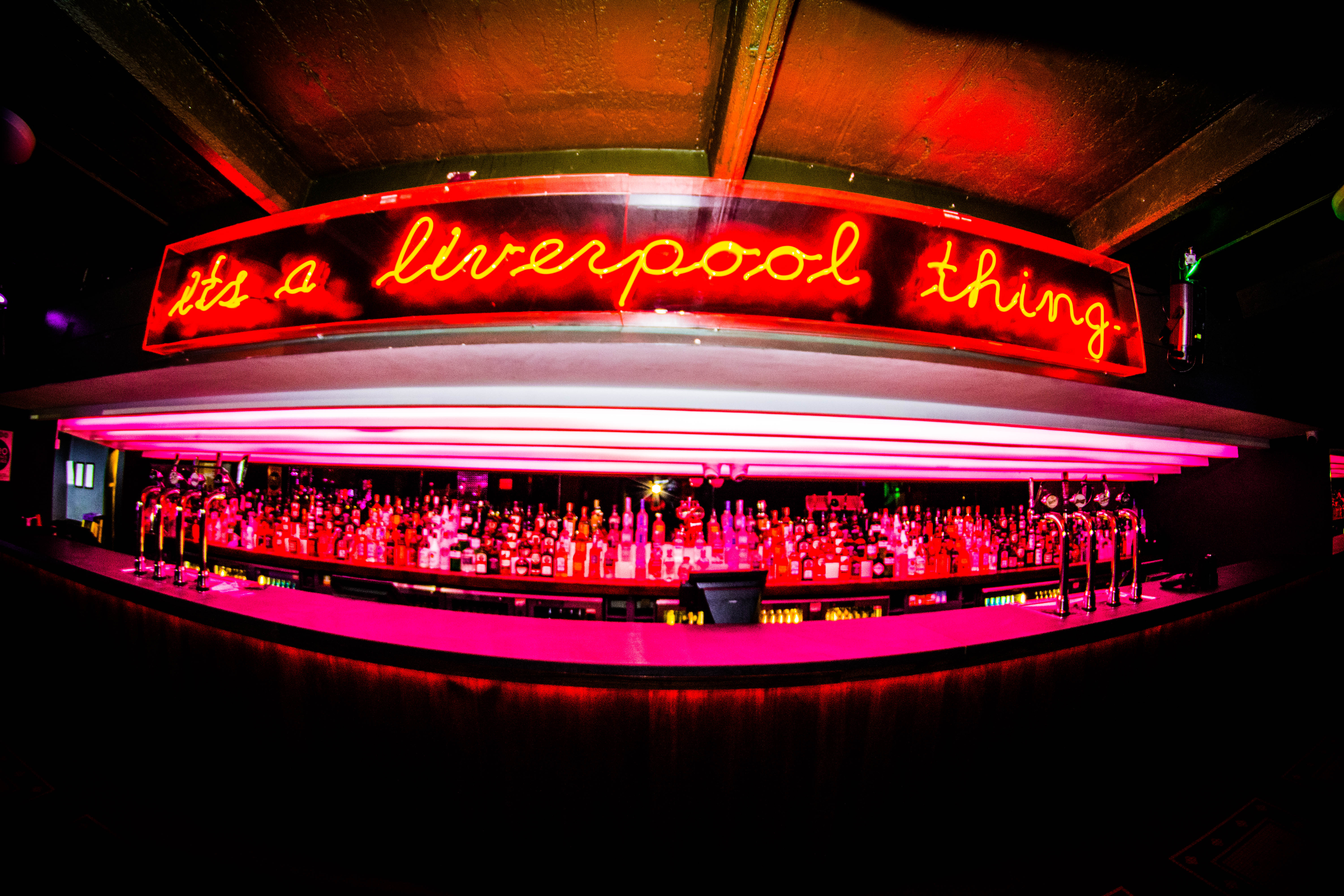Vibrant bar venue with neon sign, ideal for networking events and social gatherings.