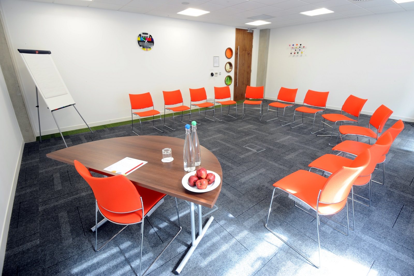 Collaborative meeting space in Manchester with orange chairs for workshops and brainstorming.