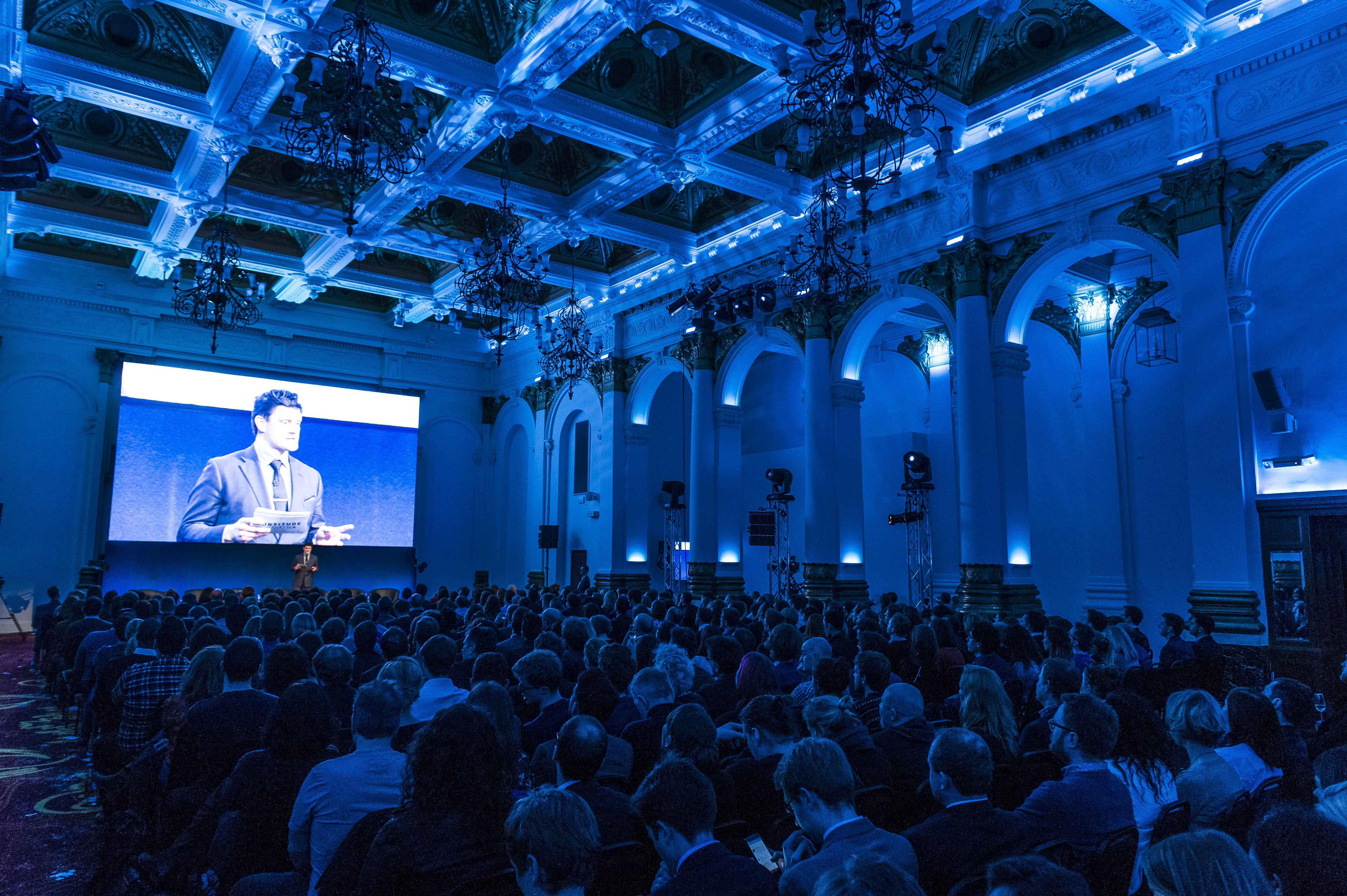 Elegant conference at The Ballroom, 8 Northumberland Avenue with blue lighting and large screen.