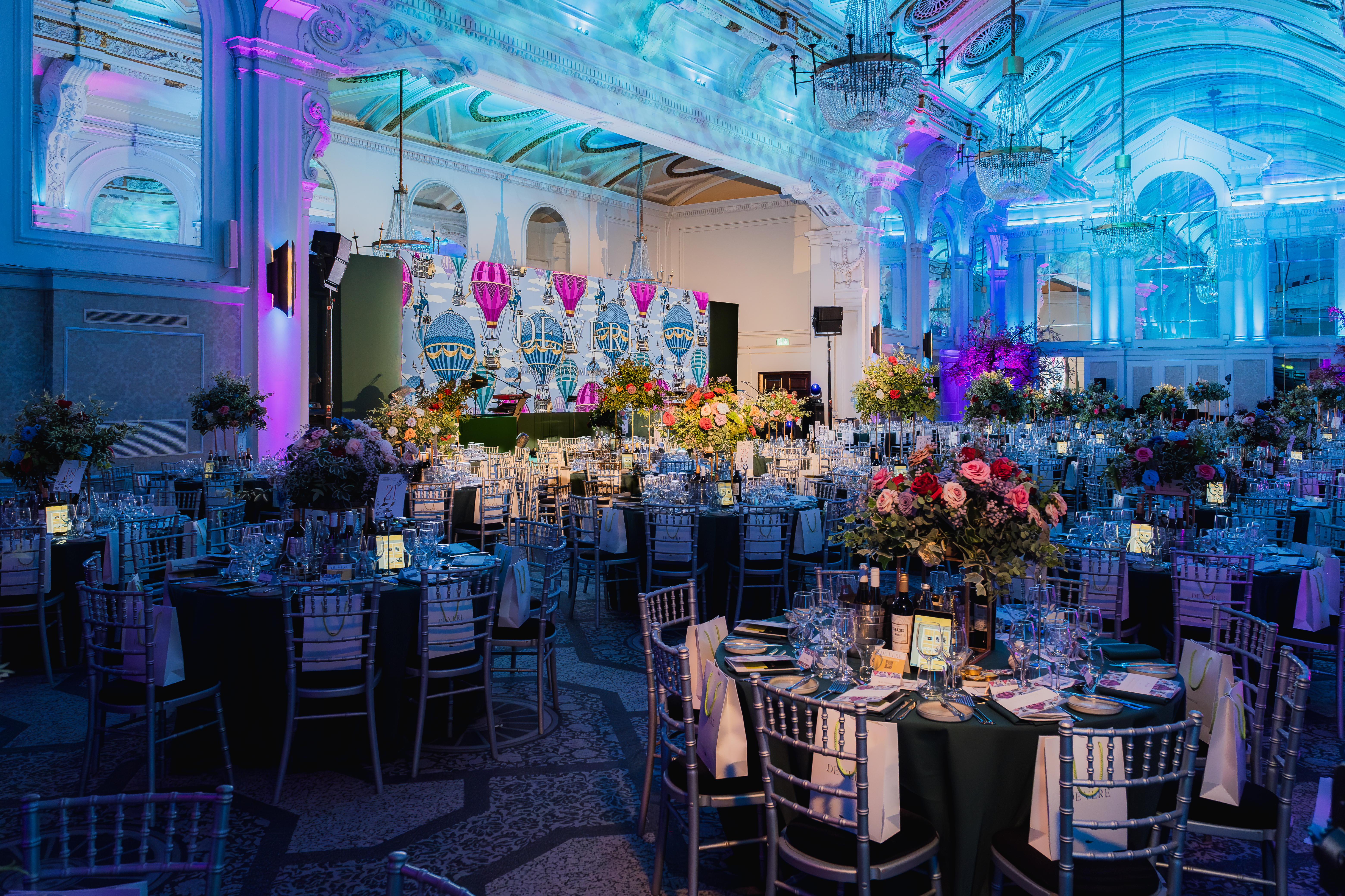 Grand Connaught Rooms gala with blue lighting and tablescapes for corporate events and weddings.