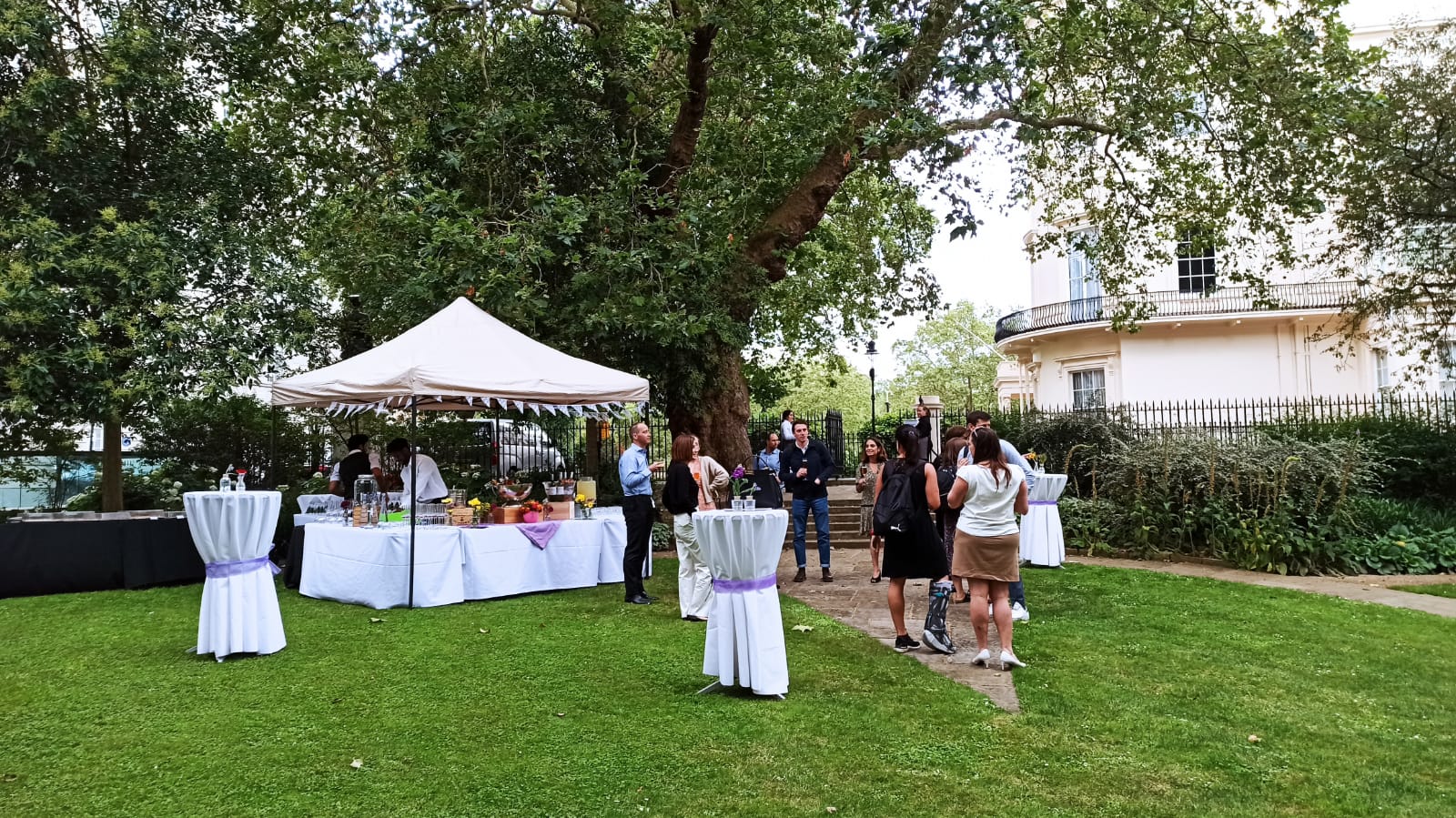 Outdoor event setup at Prince Philip House with high-top tables and lush greenery.