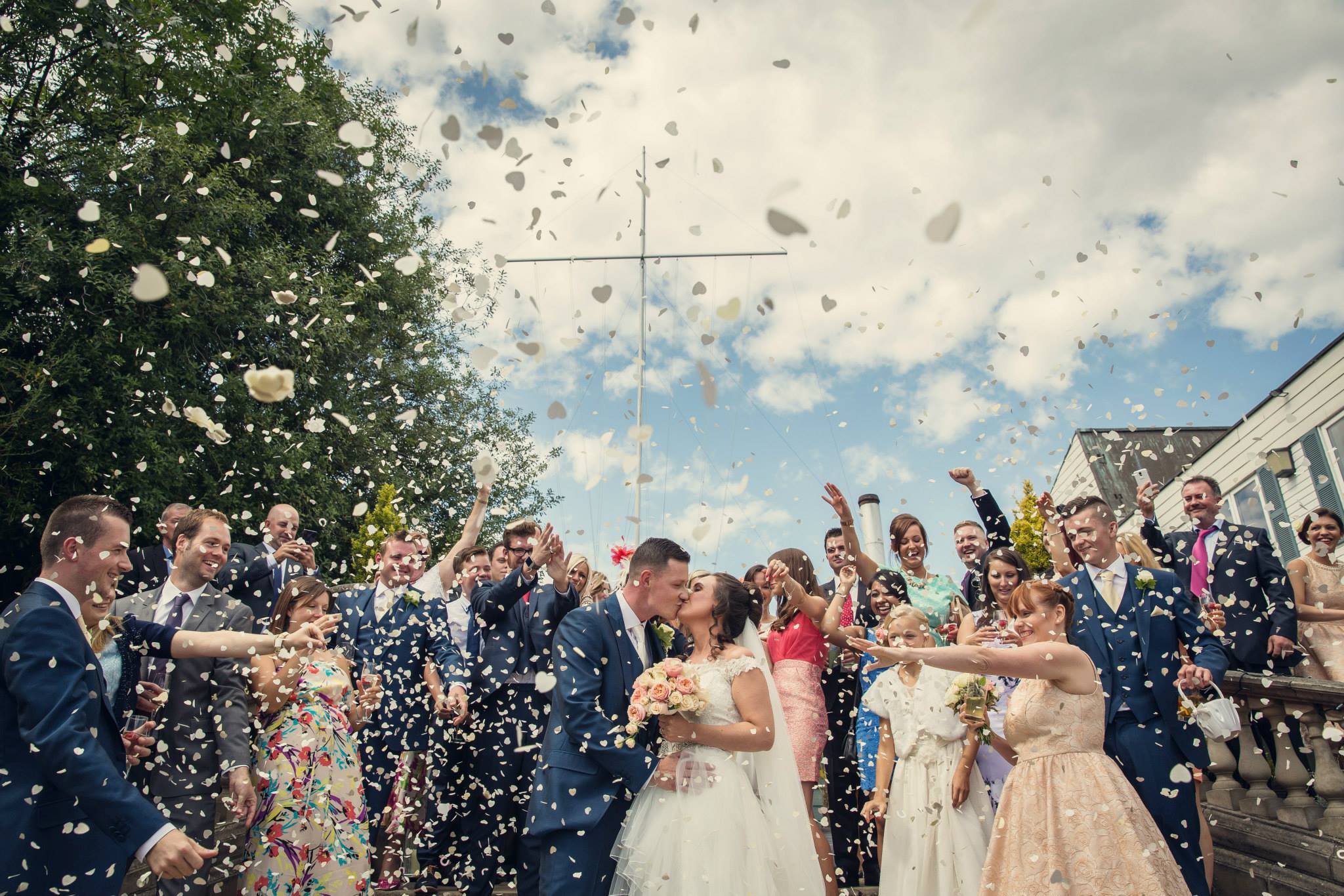 Vibrant wedding celebration in The Britannia Suite with confetti and joyful guests.