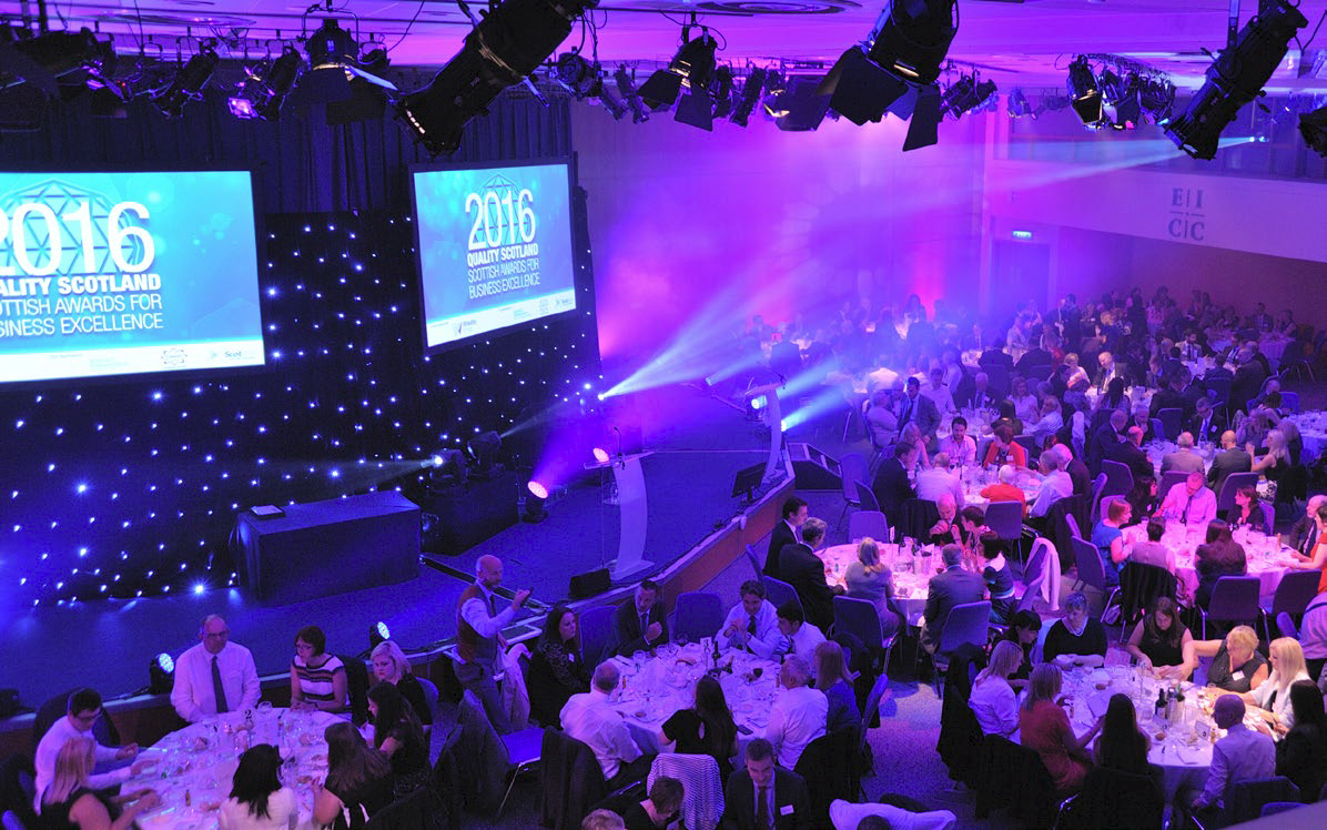 Lomond Suite awards ceremony in Edinburgh, featuring elegantly dressed attendees and dynamic lighting.