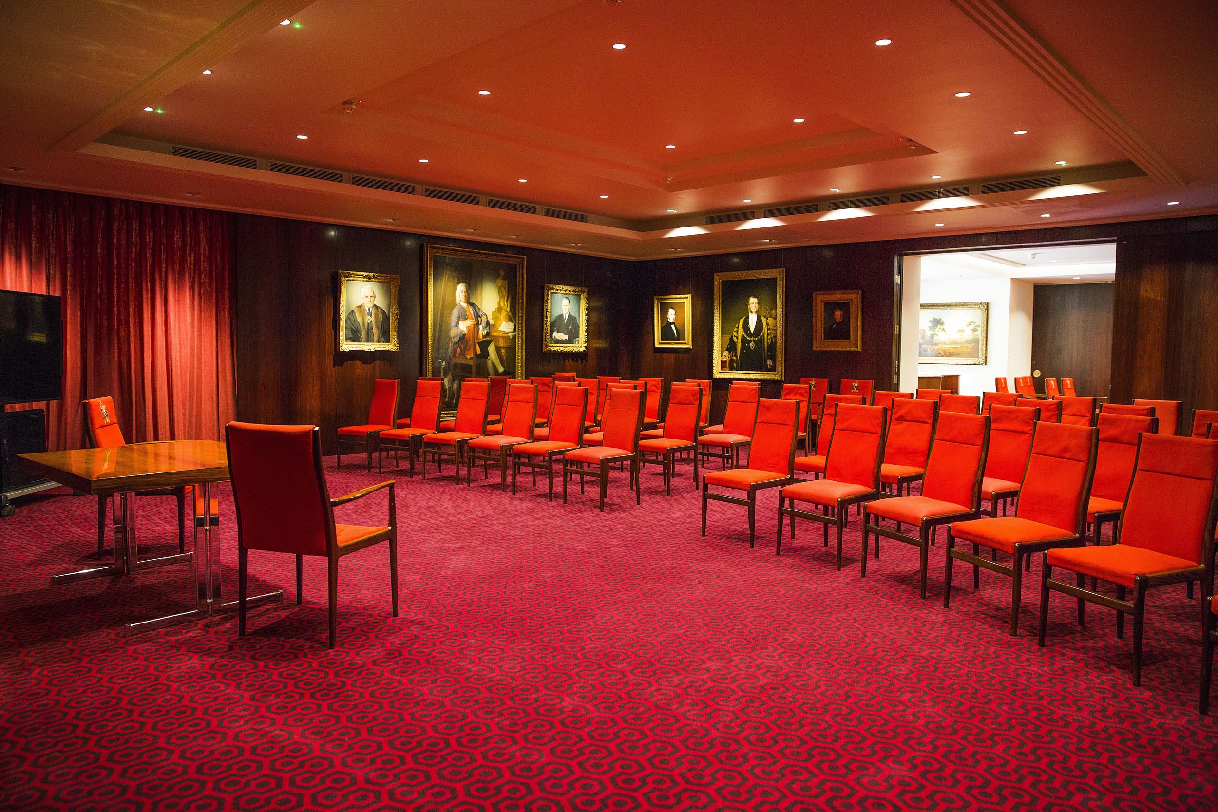 Elegant meeting room in Salters' Hall with red chairs, perfect for workshops and presentations. - Banner