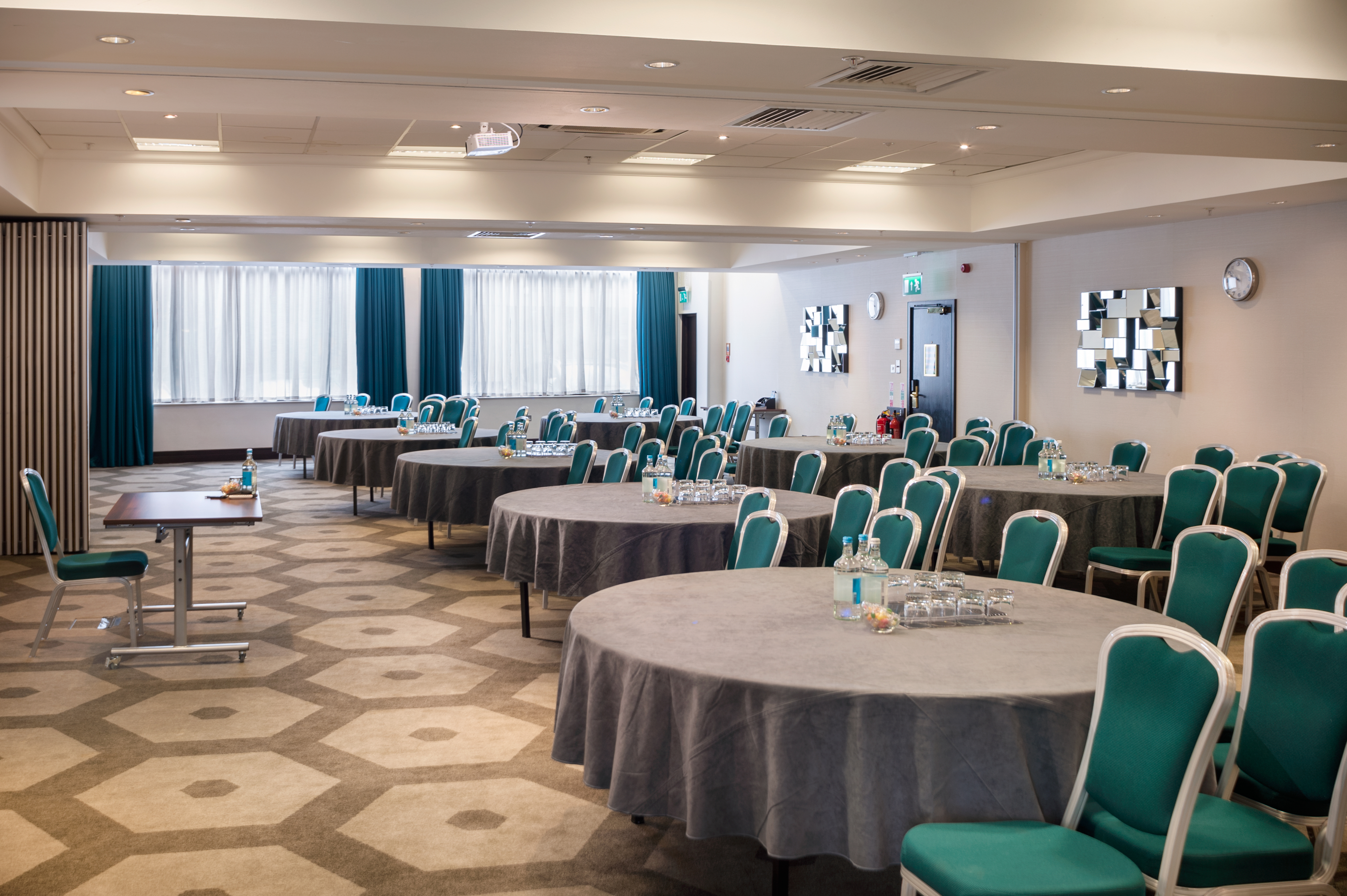Pembroke Suite at Hilton London Olympia, bright meeting space with round tables for conferences.