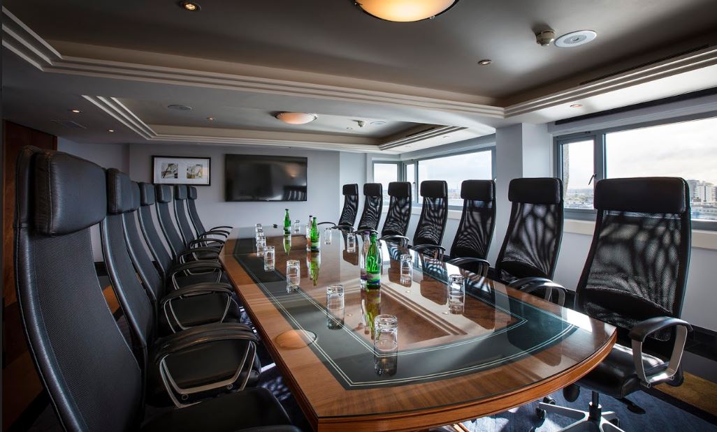 Modern boardroom in The Tower Hotel with sleek wooden table for executive meetings.