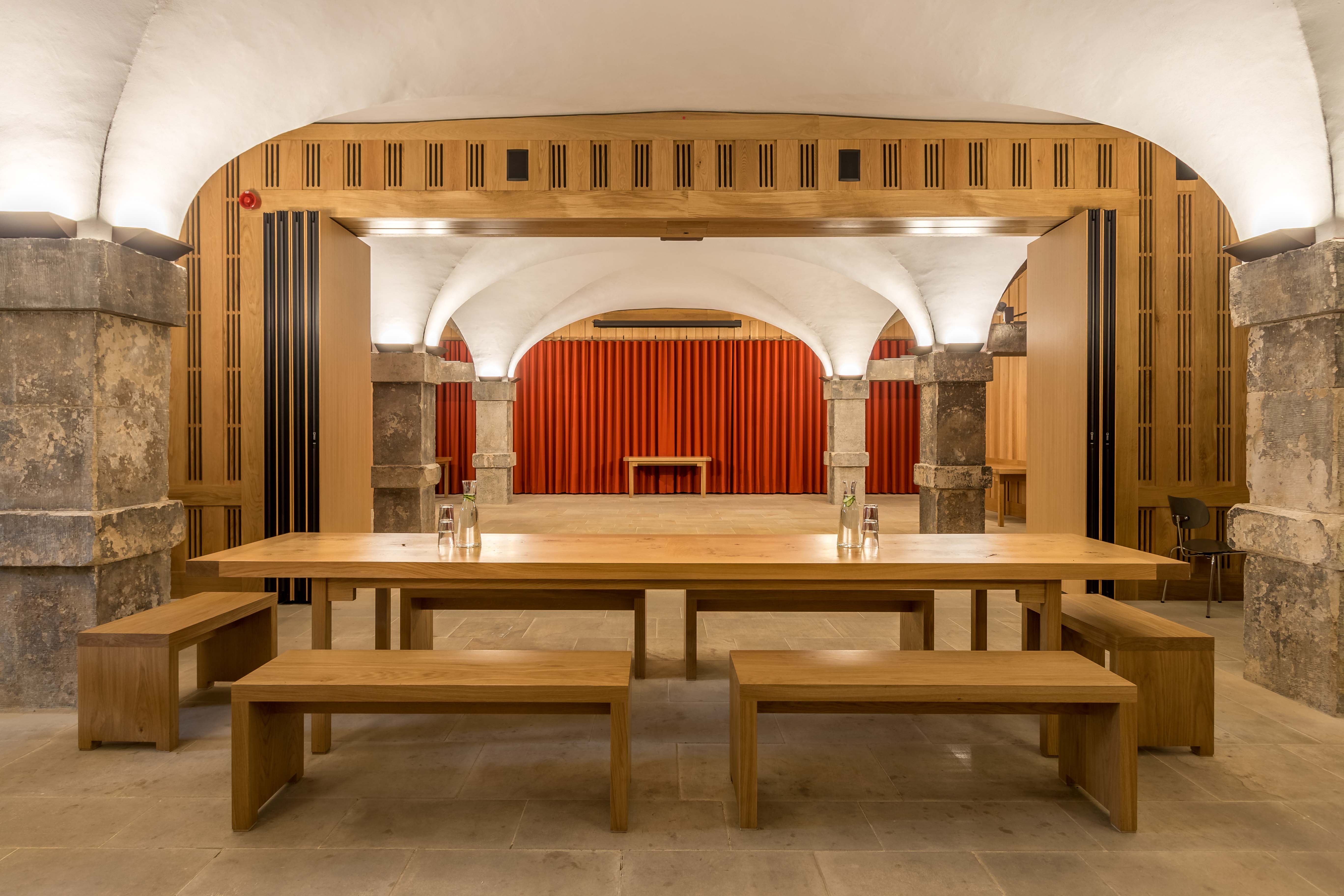 The Crypt at Christ Church Spitalfields: elegant meeting space with wooden table and arches.