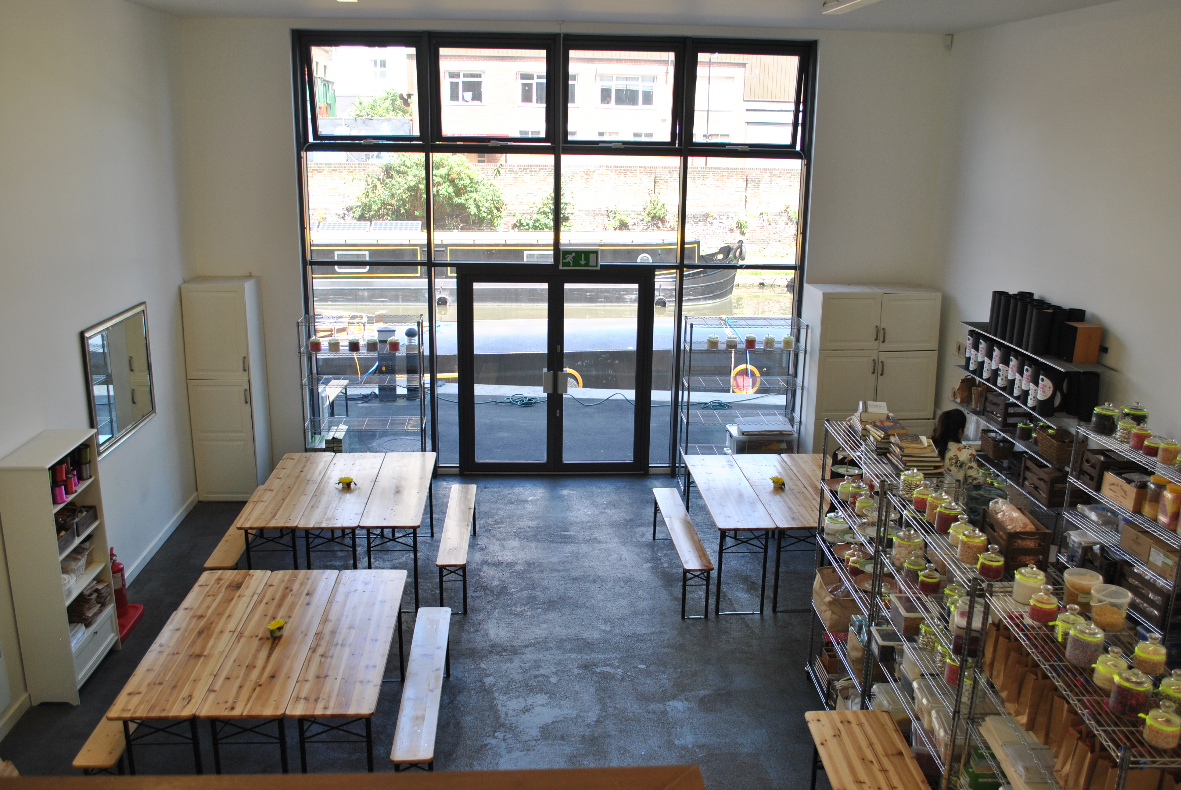 Spacious workshop venue with wooden tables and natural light for events and meetings. - Banner