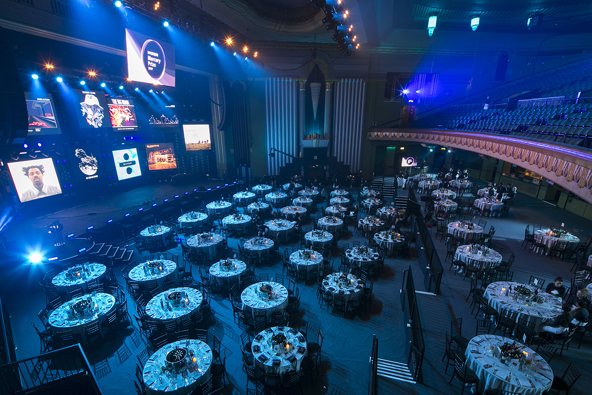 Whole Venue Eventim Apollo with elegant round tables for networking and celebration.