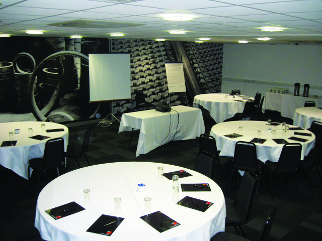 Modern conference room with round tables, ideal for meetings and presentations.