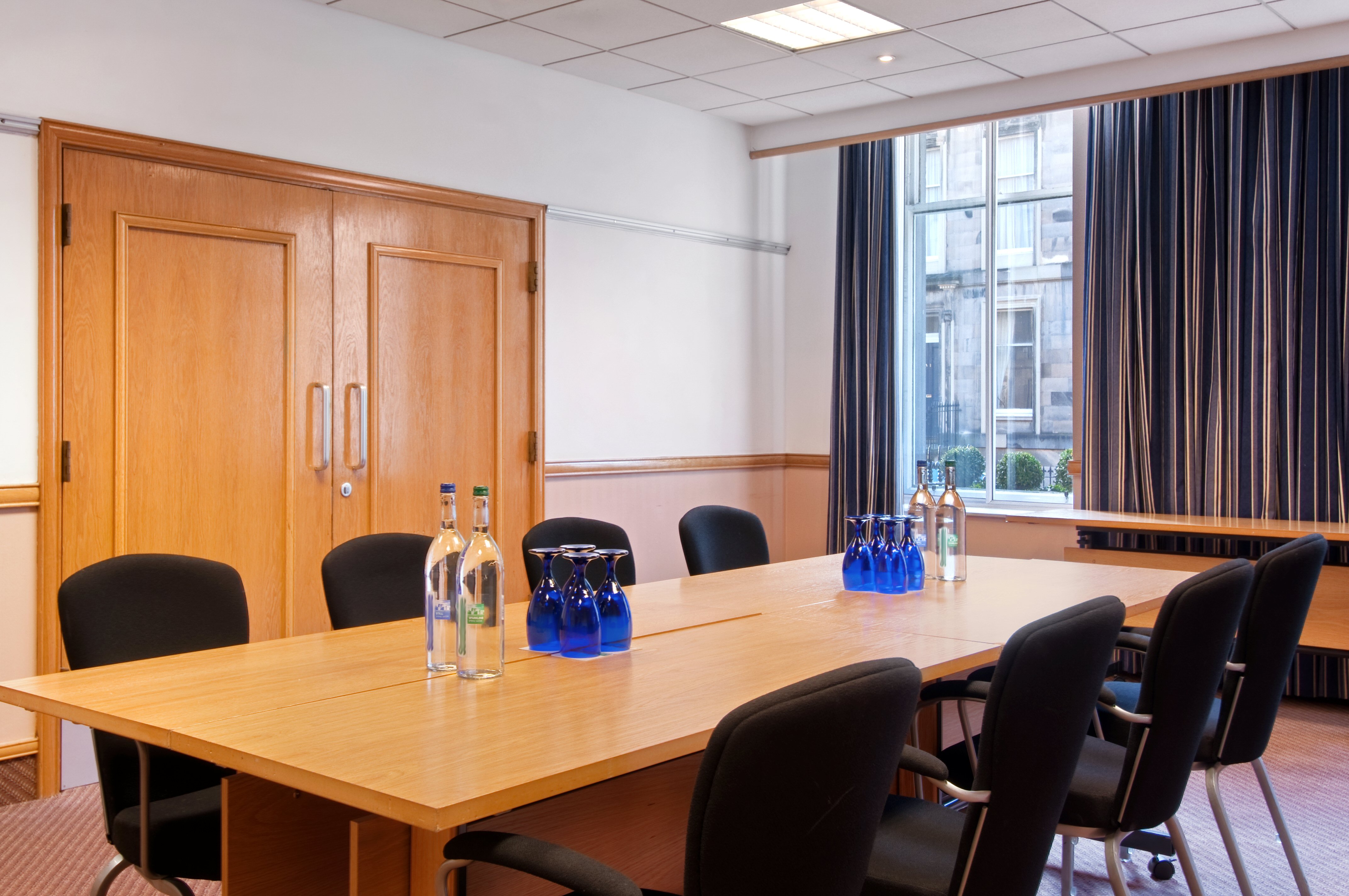 Maitland Suite meeting room at Edinburgh Grosvenor Hotel with large wooden table and chairs.