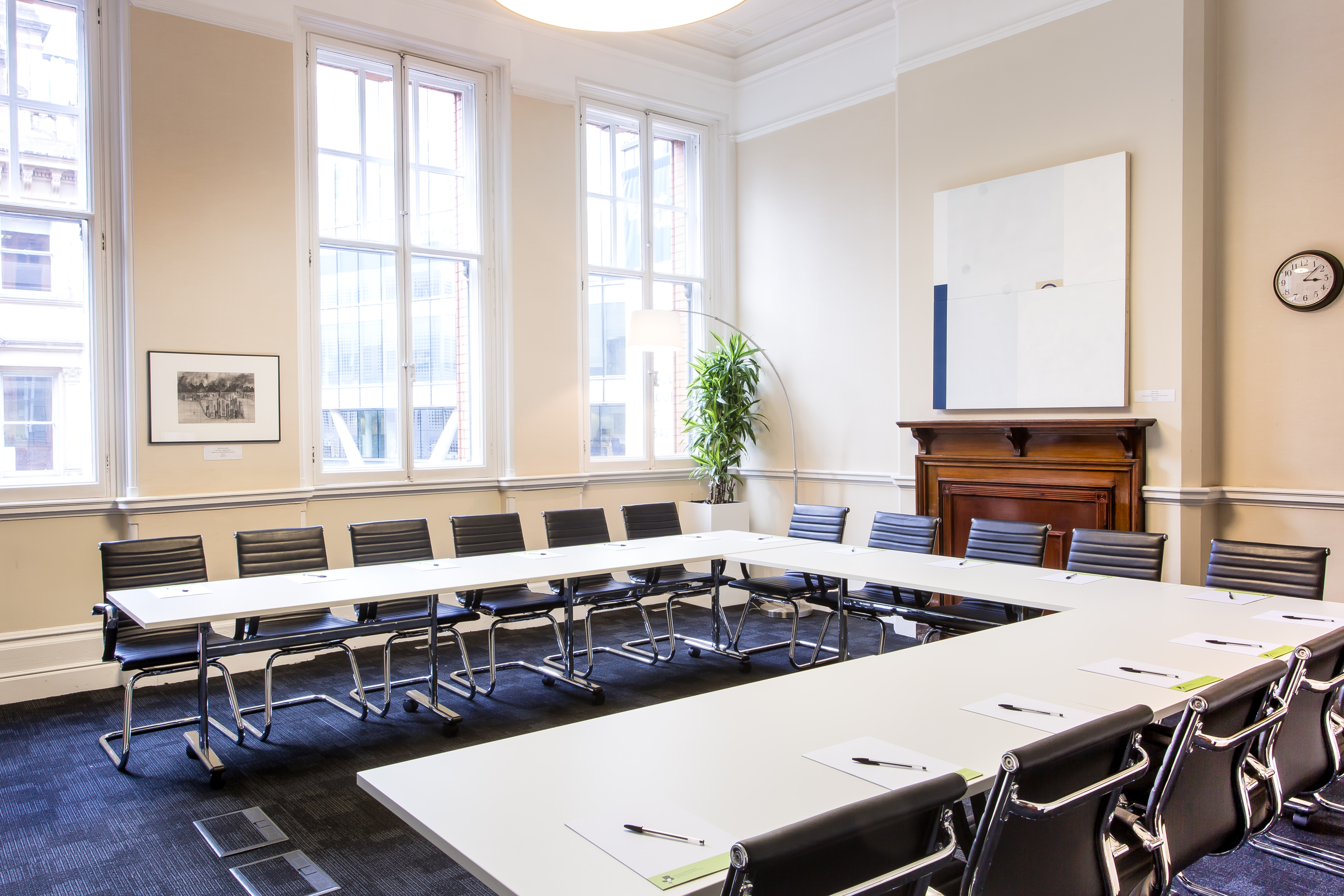 Well-lit meeting room with U-shaped table for workshops and strategic planning.