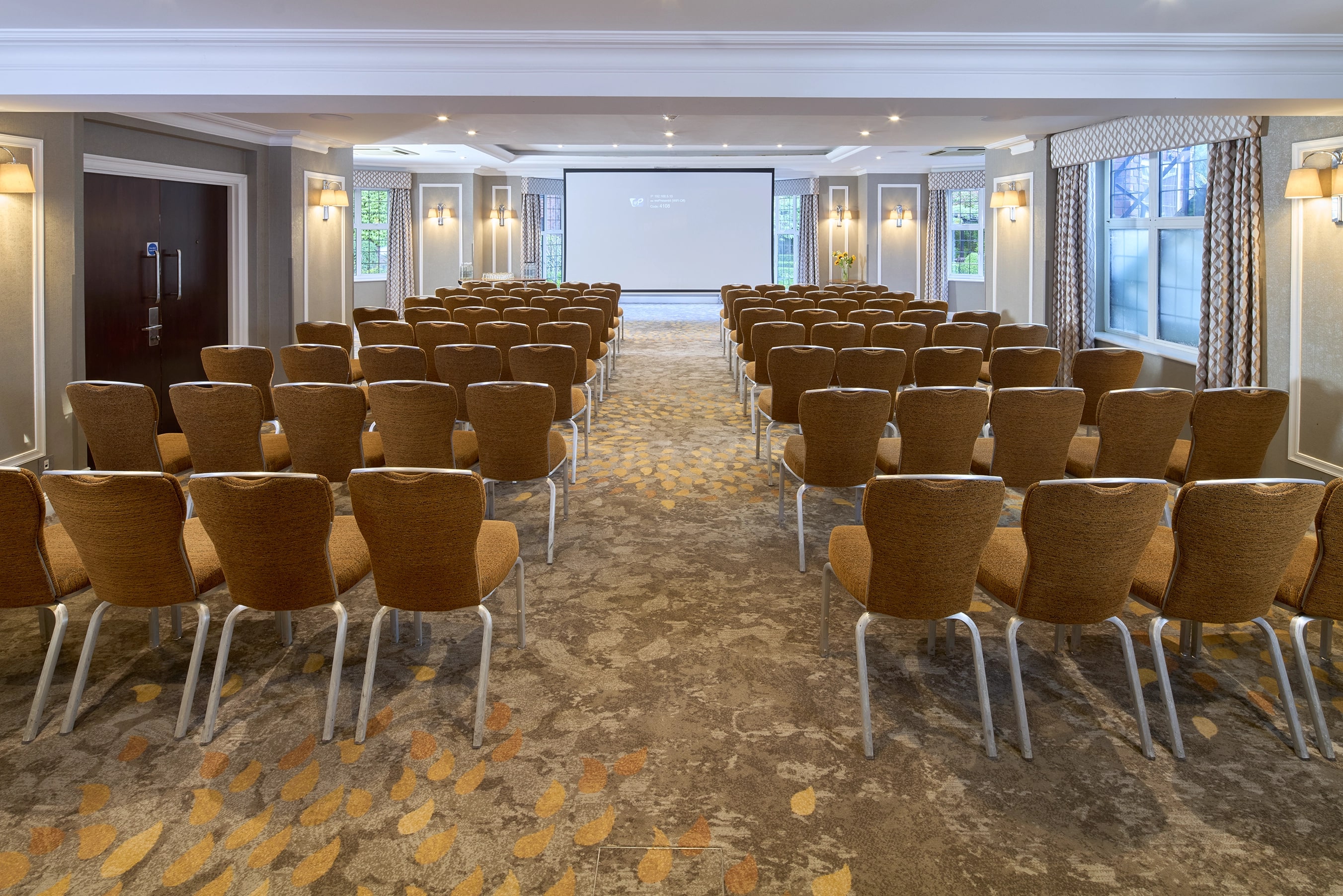 Bulstrode Suite meeting space with chairs and presentation screen, ideal for conferences.