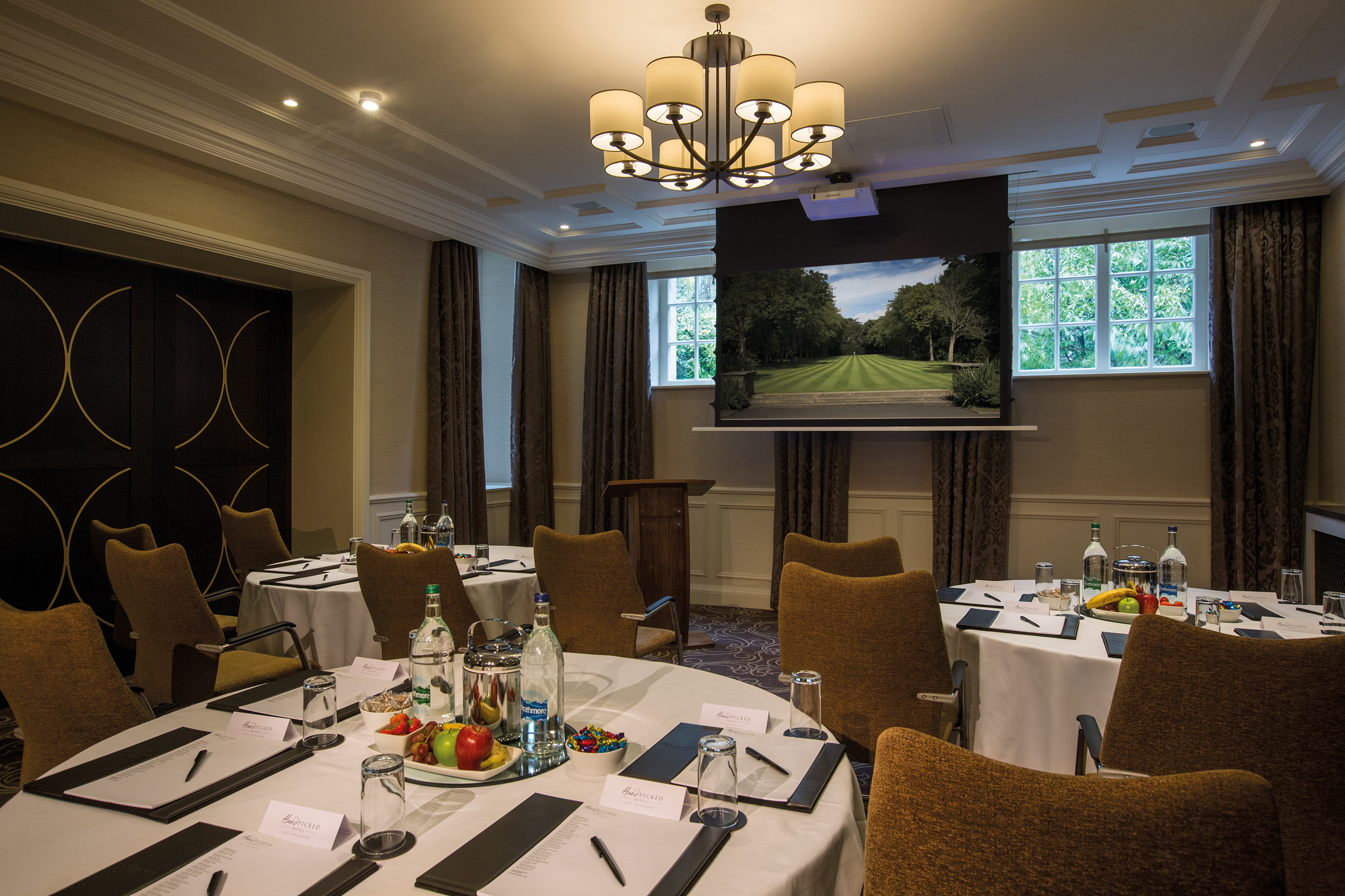 Meeting room at Crathorne Hall Hotel with round tables for professional gatherings.