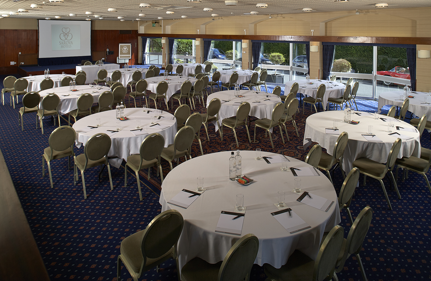 Elgar Suite at The Abbey Hotel, bright conference room with round tables for events.