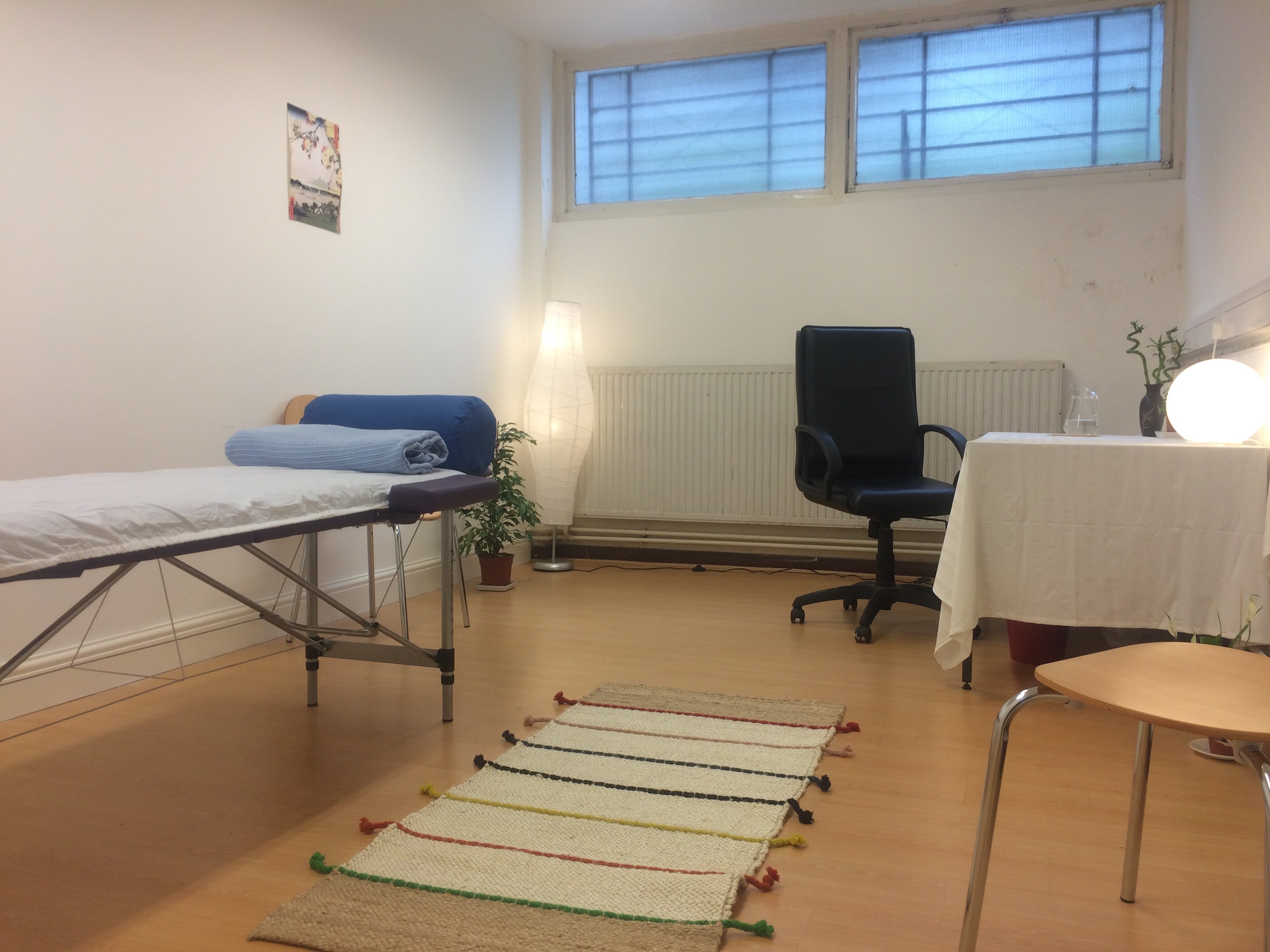 Serene therapy room with treatment table, ideal for wellness workshops and consultations.