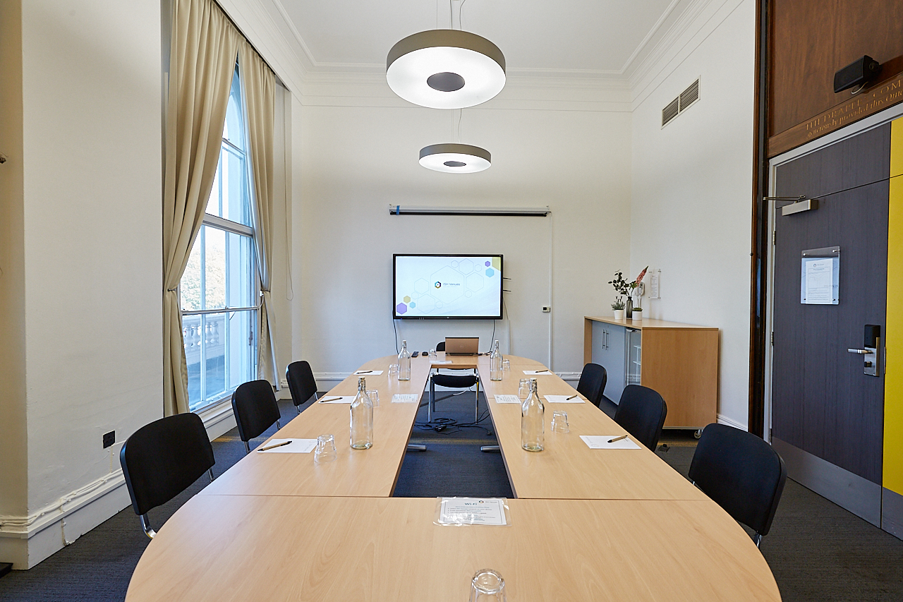 Modern meeting room with long table, ideal for professional gatherings and presentations.