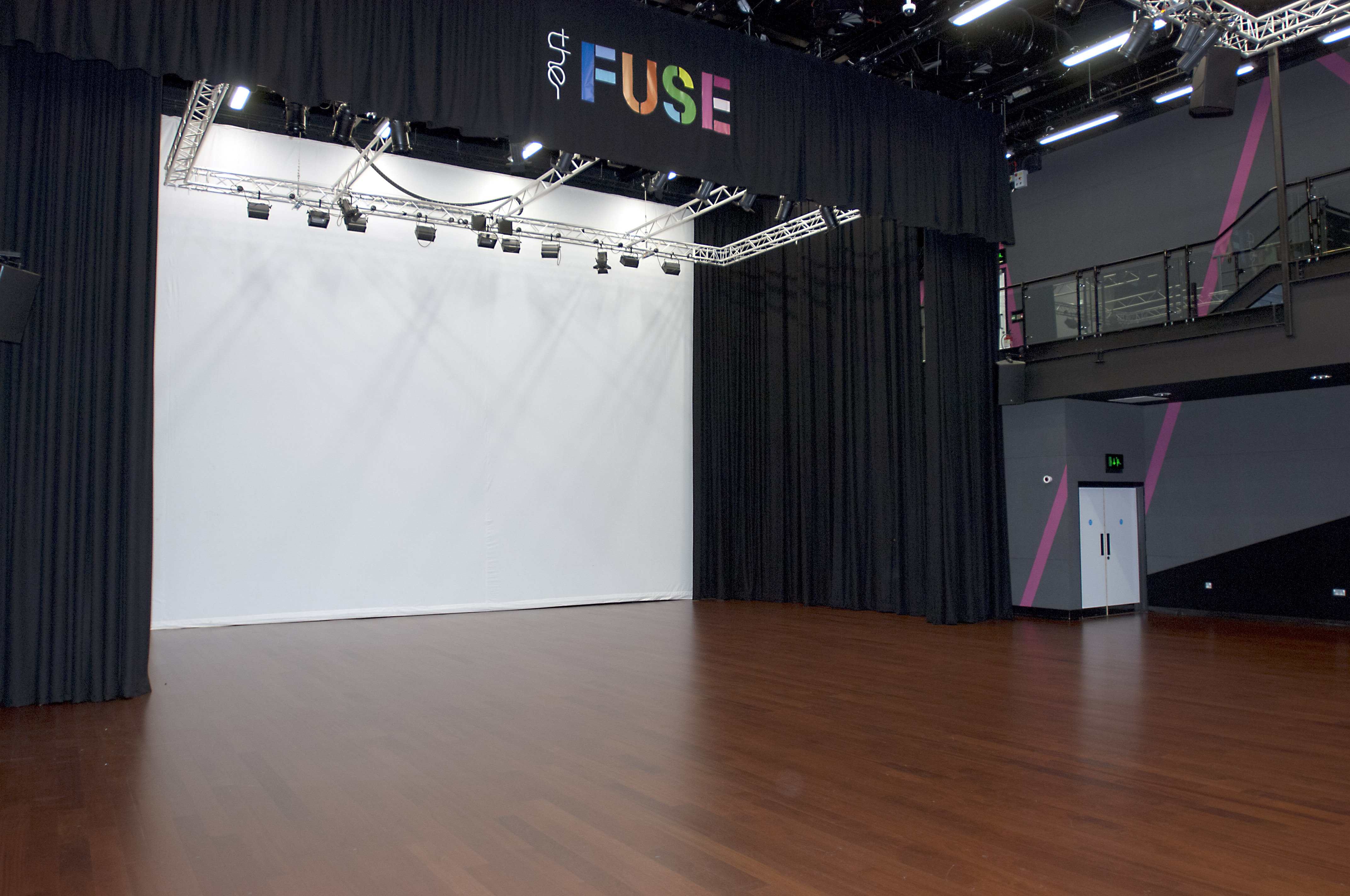 Versatile auditorium with polished wooden floor for presentations and performances.