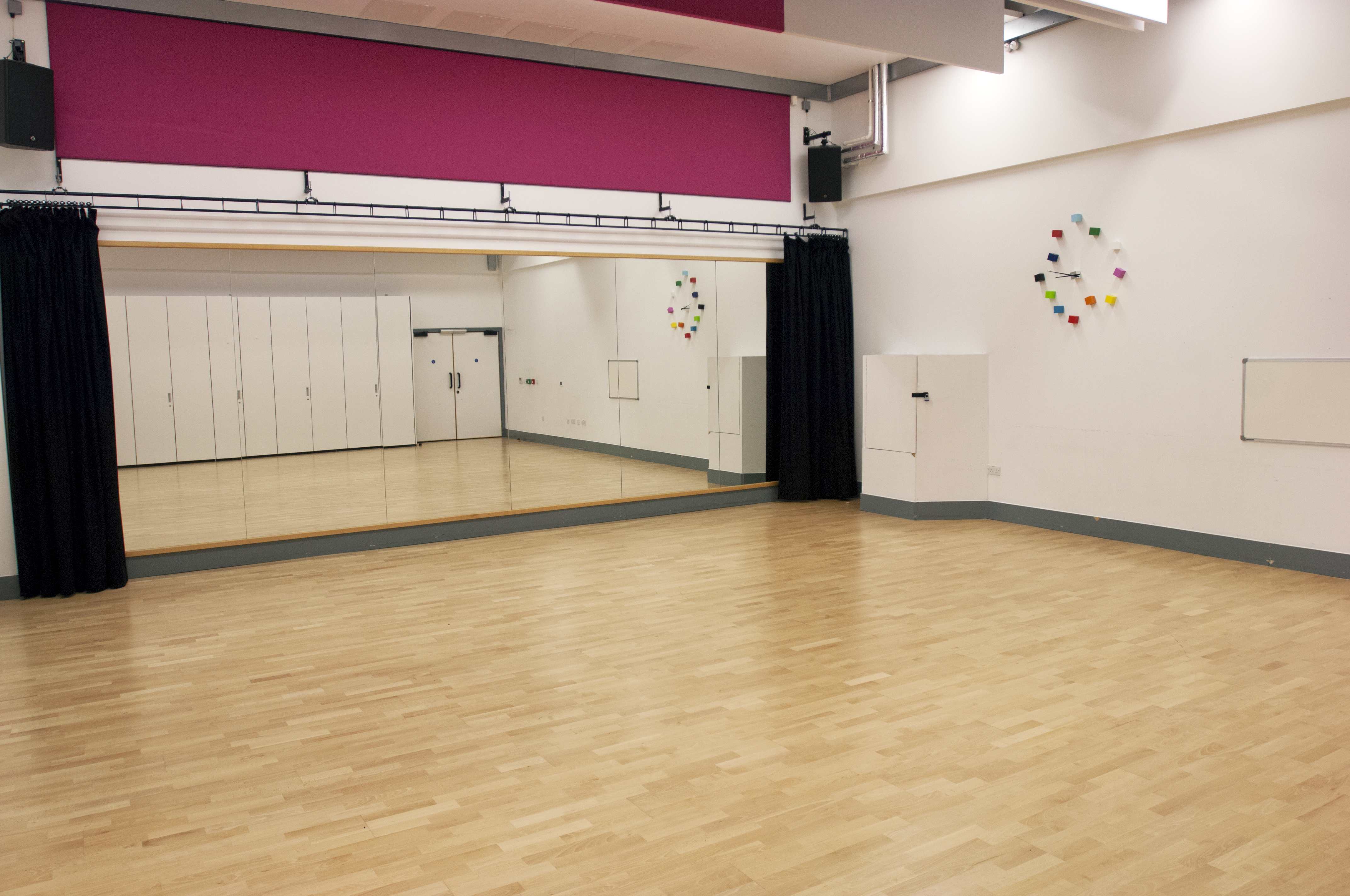 Dance studio with polished wooden floor, ideal for workshops and dance classes.