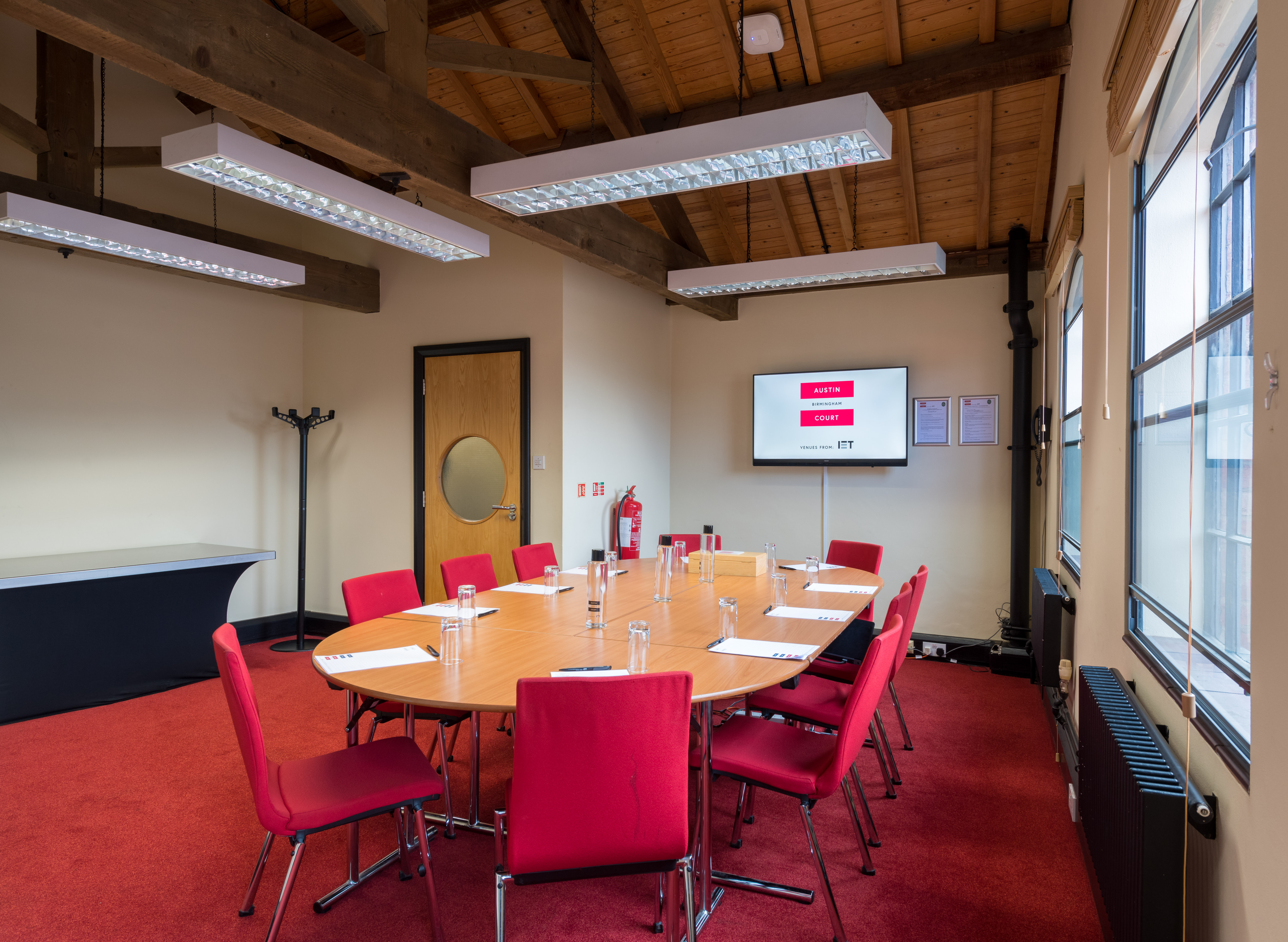 Randall Room at IET Birmingham: round table meeting space with red chairs for collaboration.