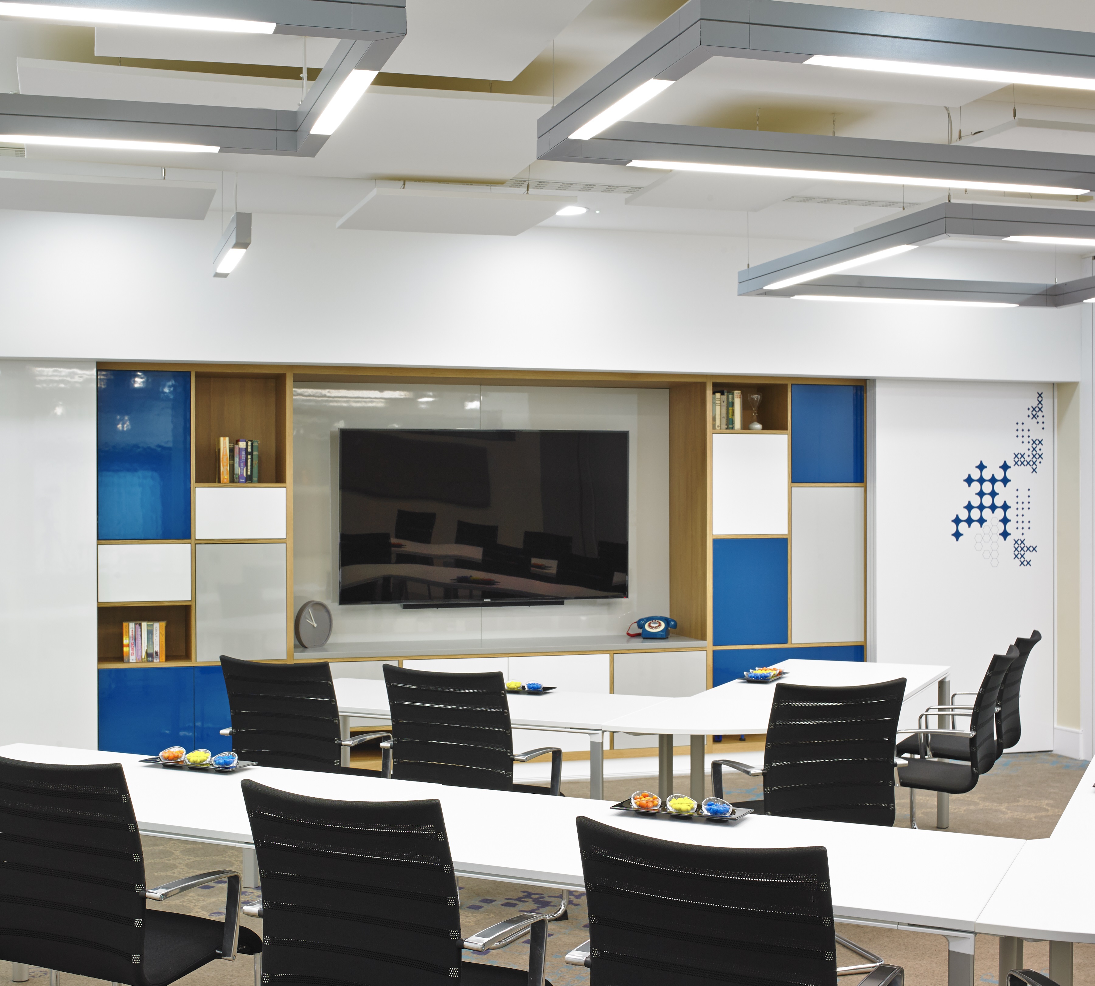 Modern meeting room at London Marriott Kensington with large screen and blue accents.