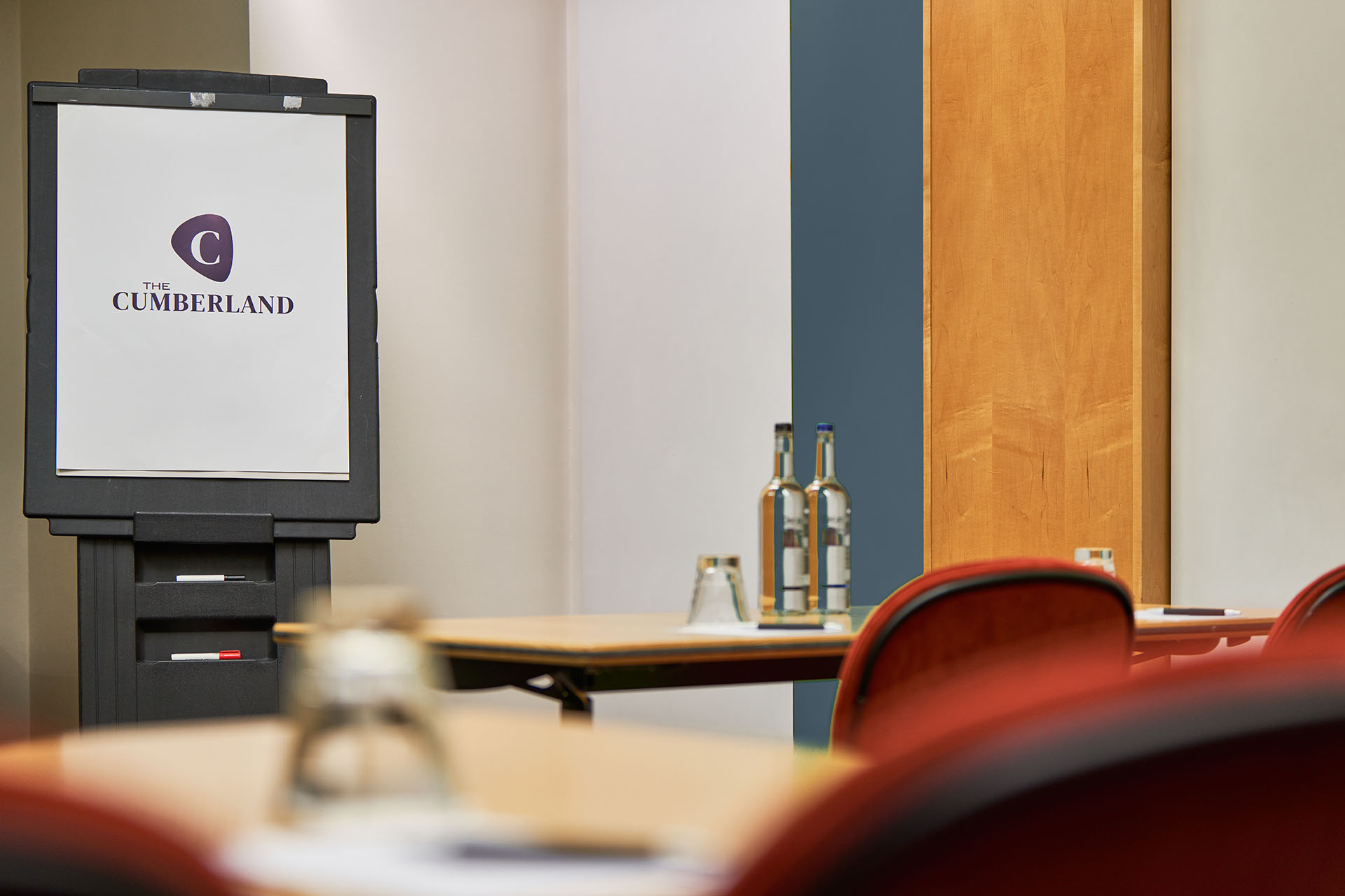 Meeting space in Studio 8, Cumberland Hotel, with branded board and organized tables.