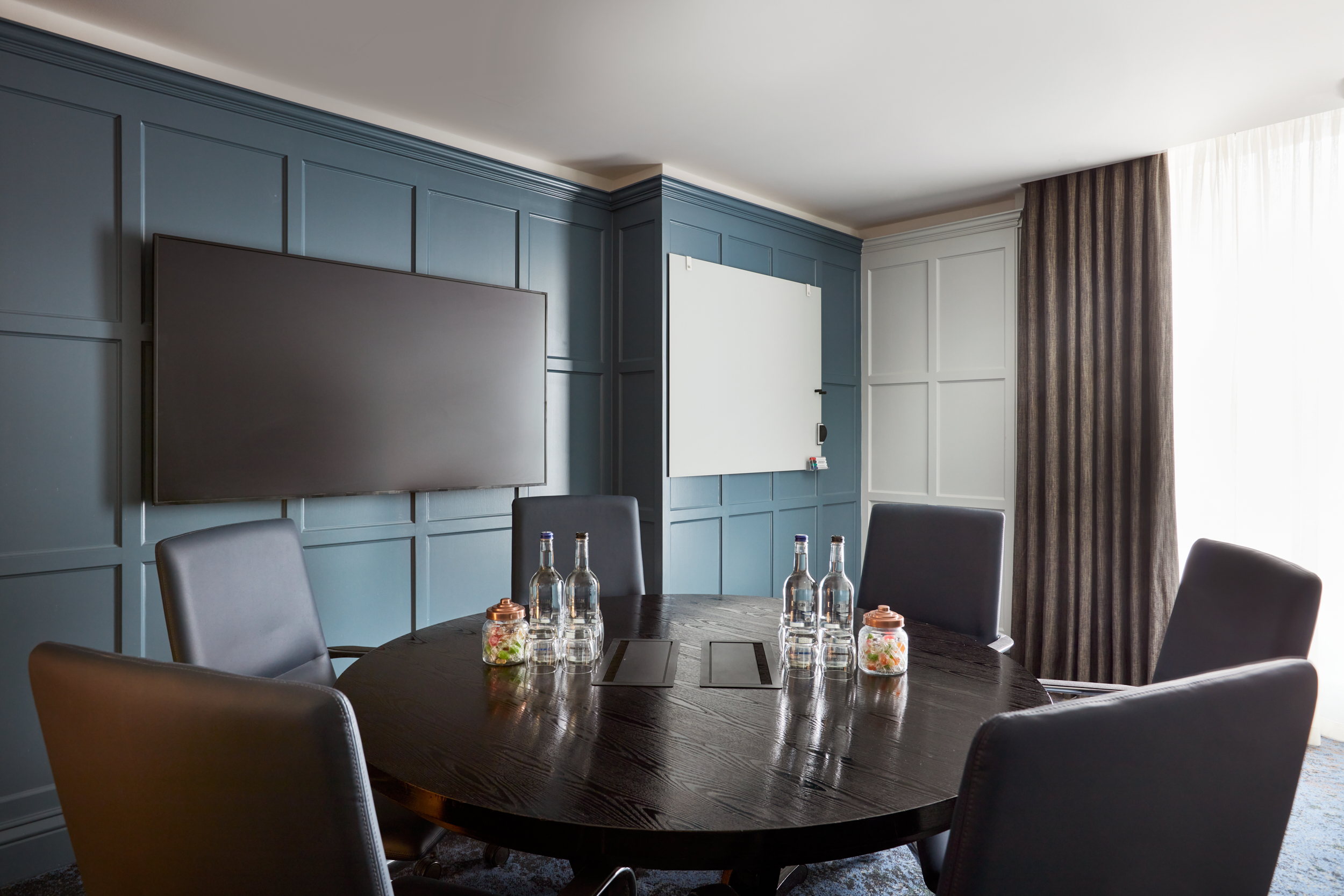 Modern boardroom with round table, ideal for meetings and presentations at The Ghan.