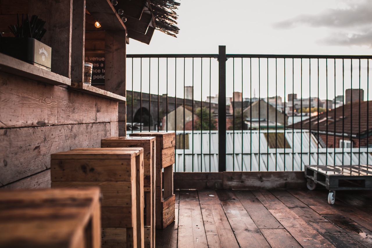 Stylish rooftop venue with wooden seating, ideal for networking and gatherings.