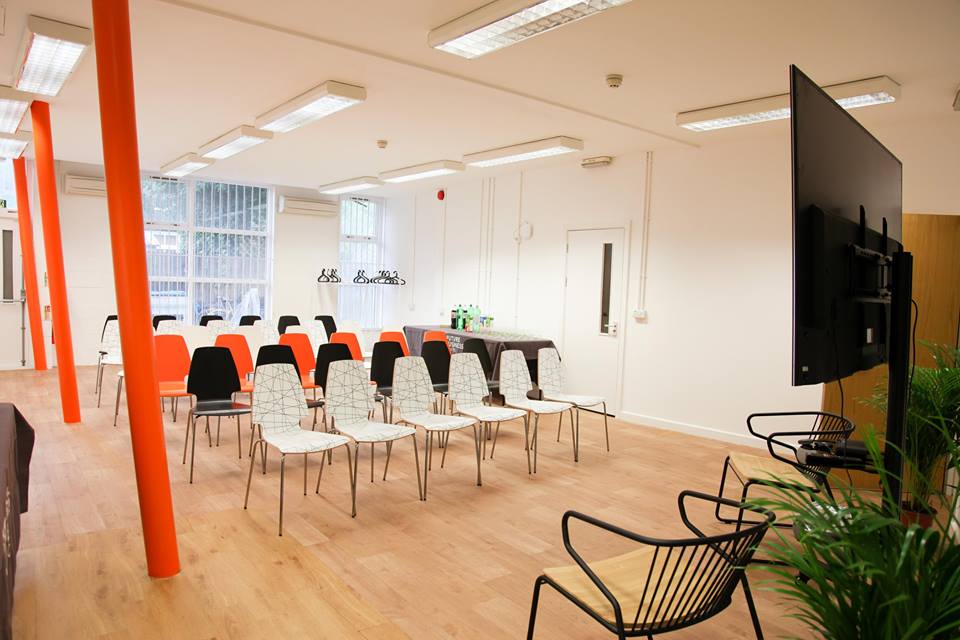 Modern conference space with colorful chairs for engaging workshops in East London. - Banner