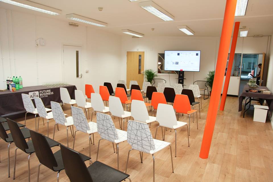 Modern event space with colorful chairs and a large screen in East London. - Banner