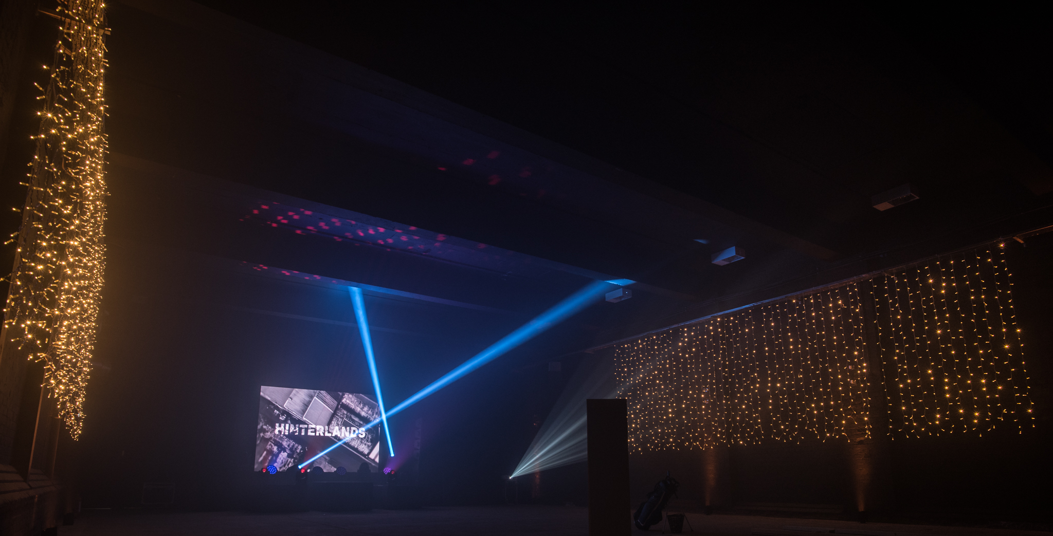 Eclipse Theatre in Hinterlands: vibrant event space with dynamic lighting and multimedia screen. - Banner