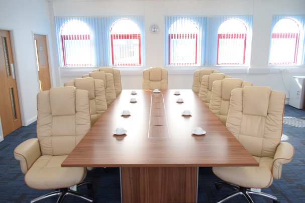 Executive conference room with wooden table, ideal for meetings and presentations.