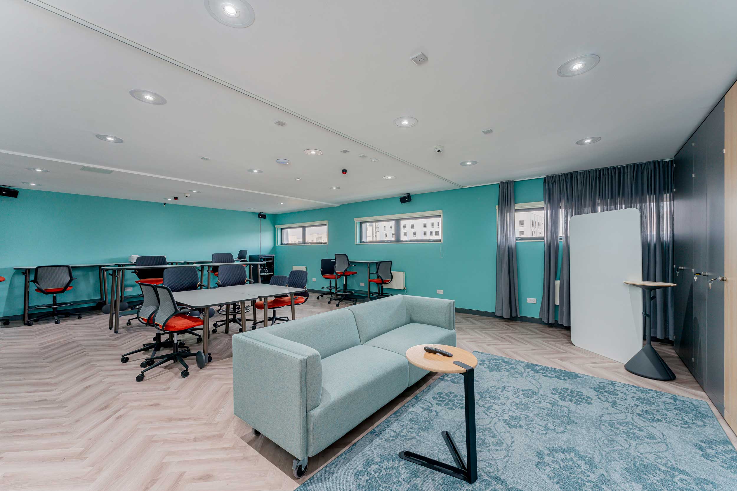 Versatile meeting space in FACT Liverpool with turquoise walls, ideal for workshops and brainstorming.