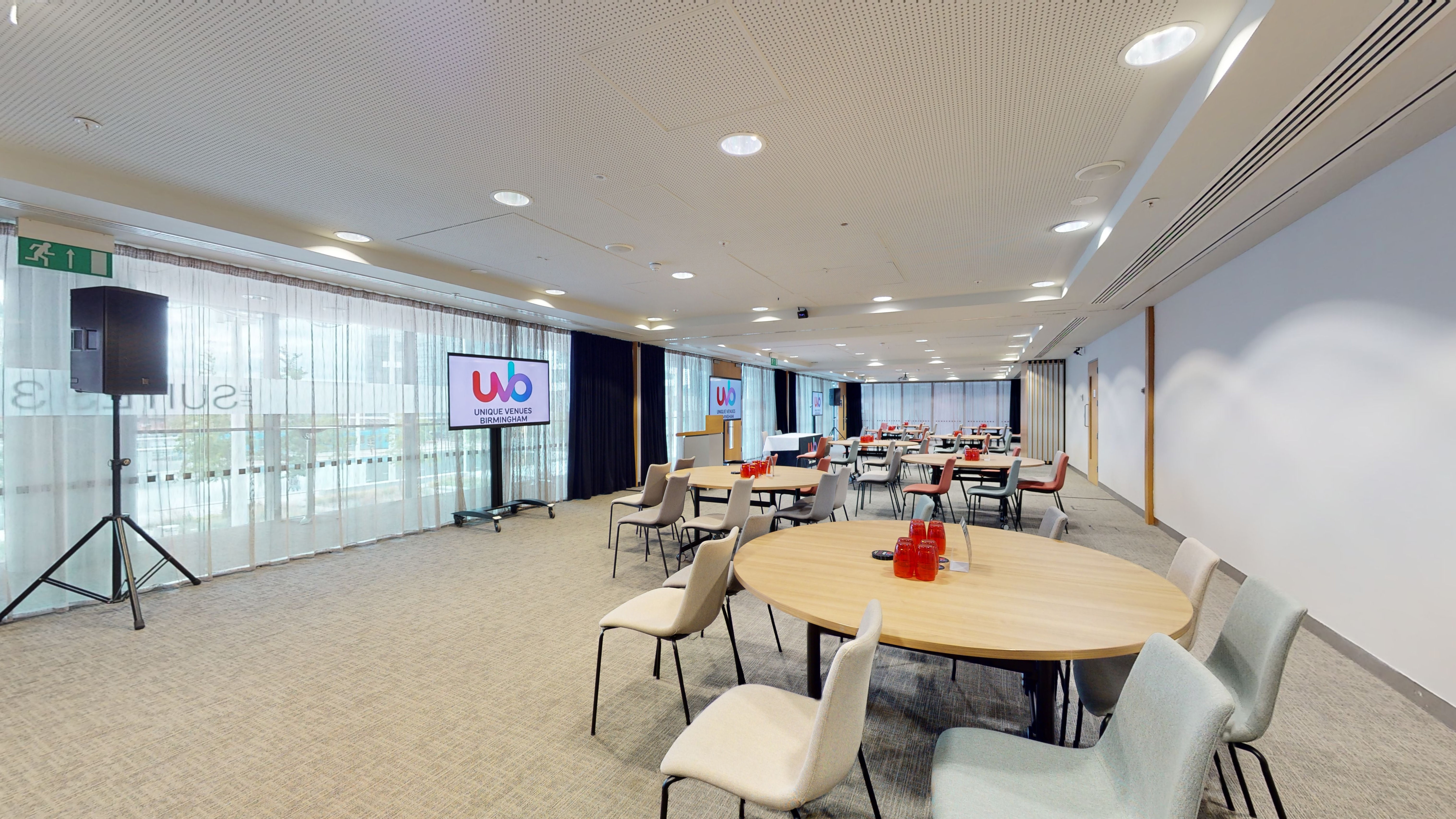 Versatile meeting space with round tables and AV setup at Unique Venues Birmingham.