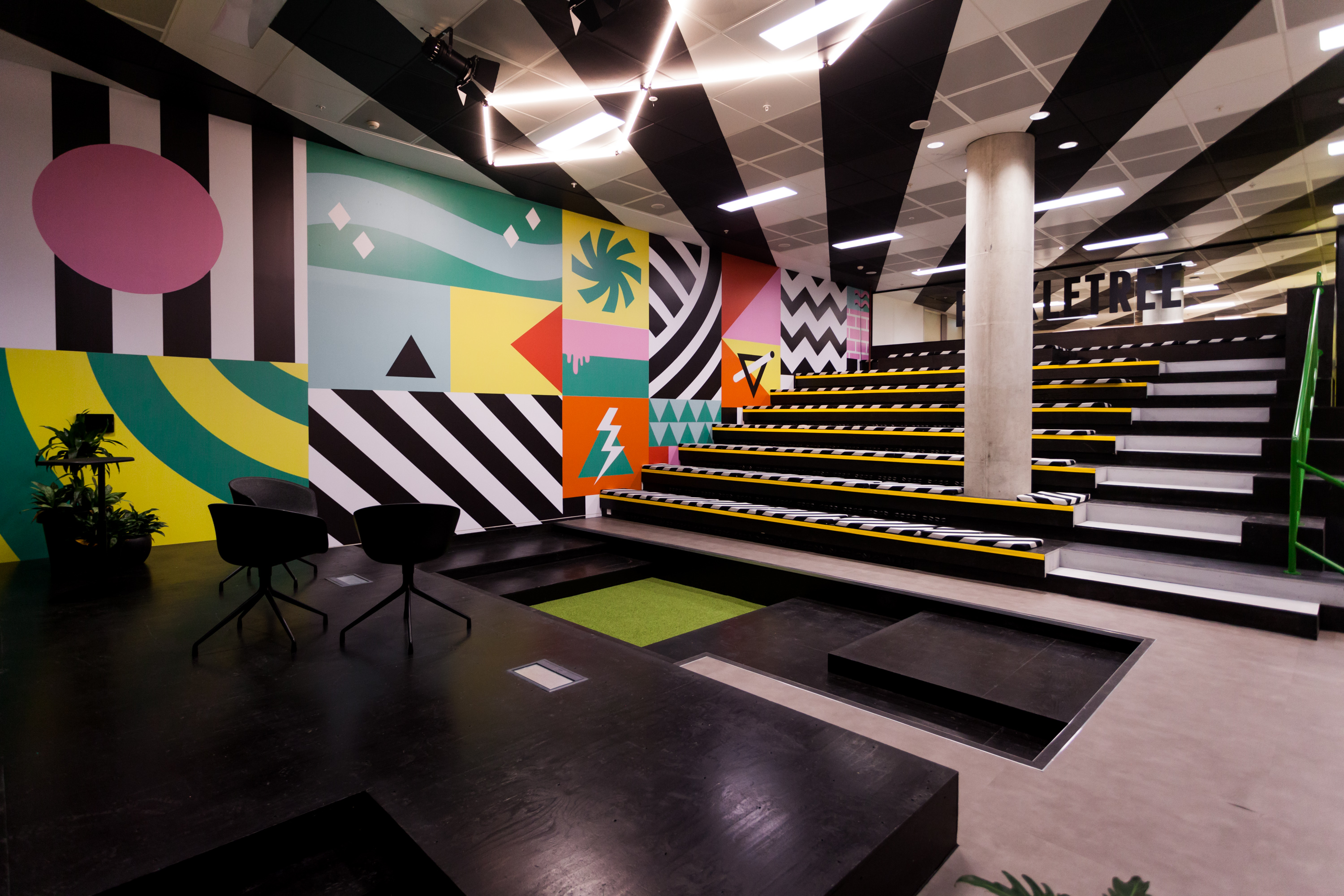 Modern auditorium with geometric wall art, perfect for workshops and presentations.