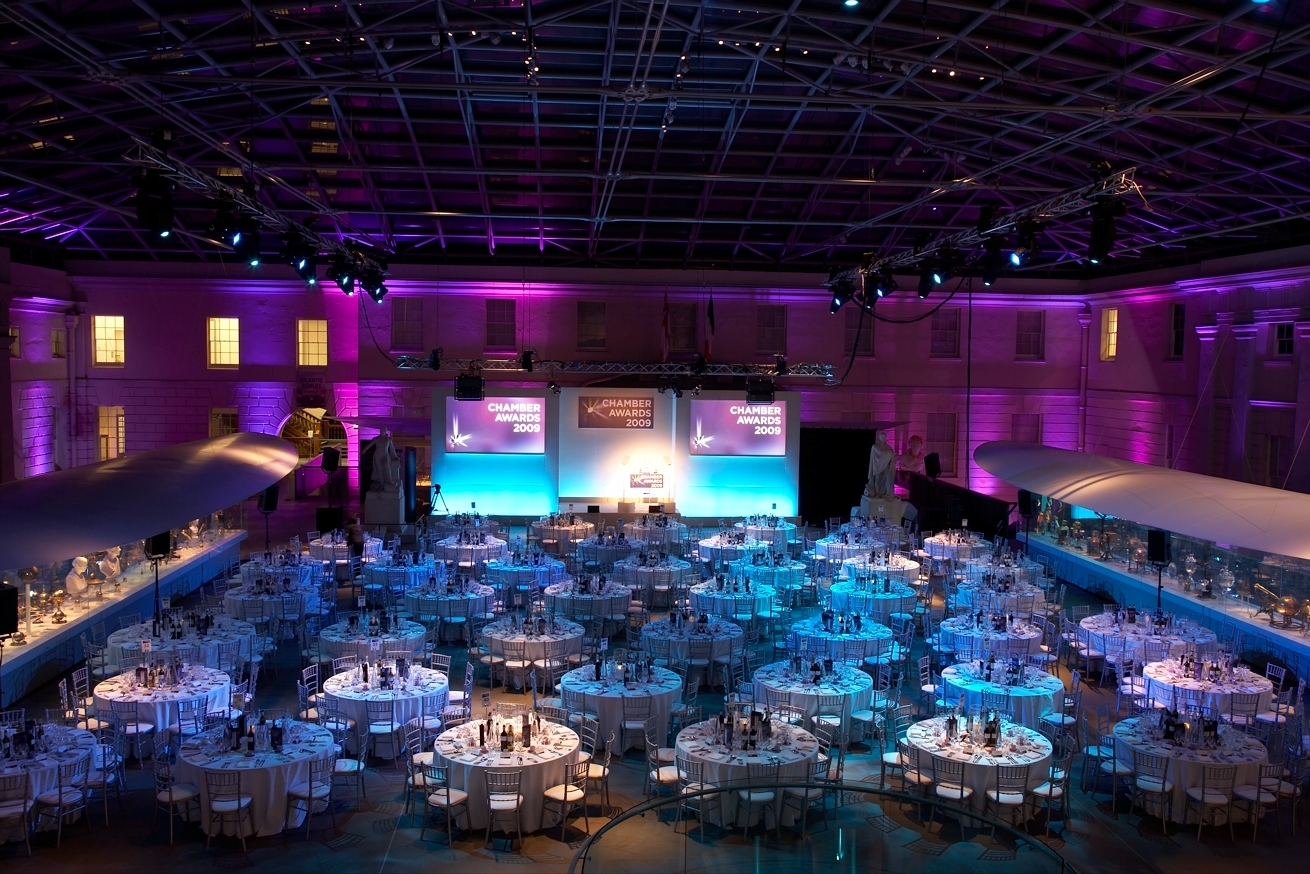 Elegant gala setup at National Maritime Museum with blue-purple lighting and round tables.
