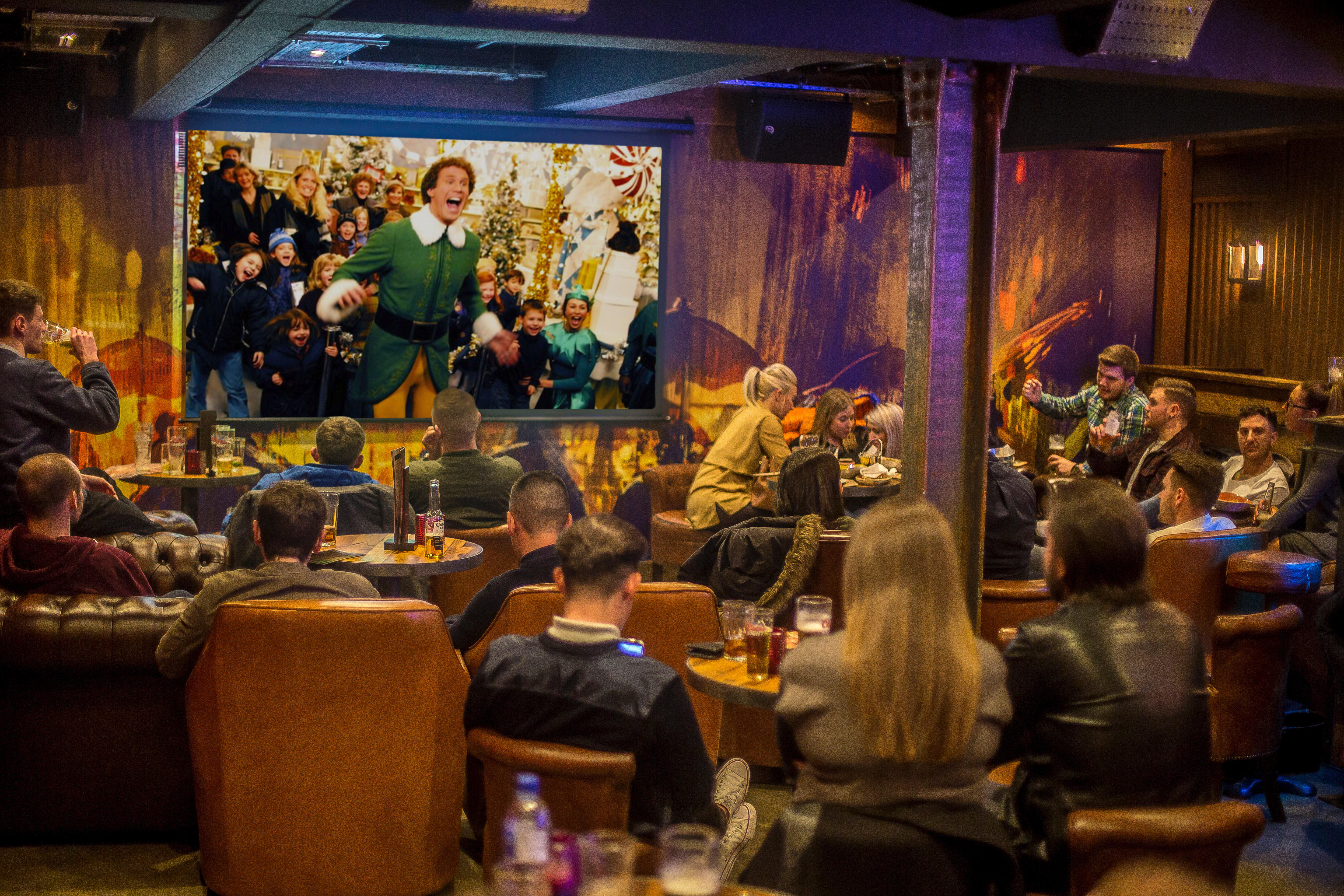 Lively holiday event at The Bar, Dive NQ with festive atmosphere and large screen.