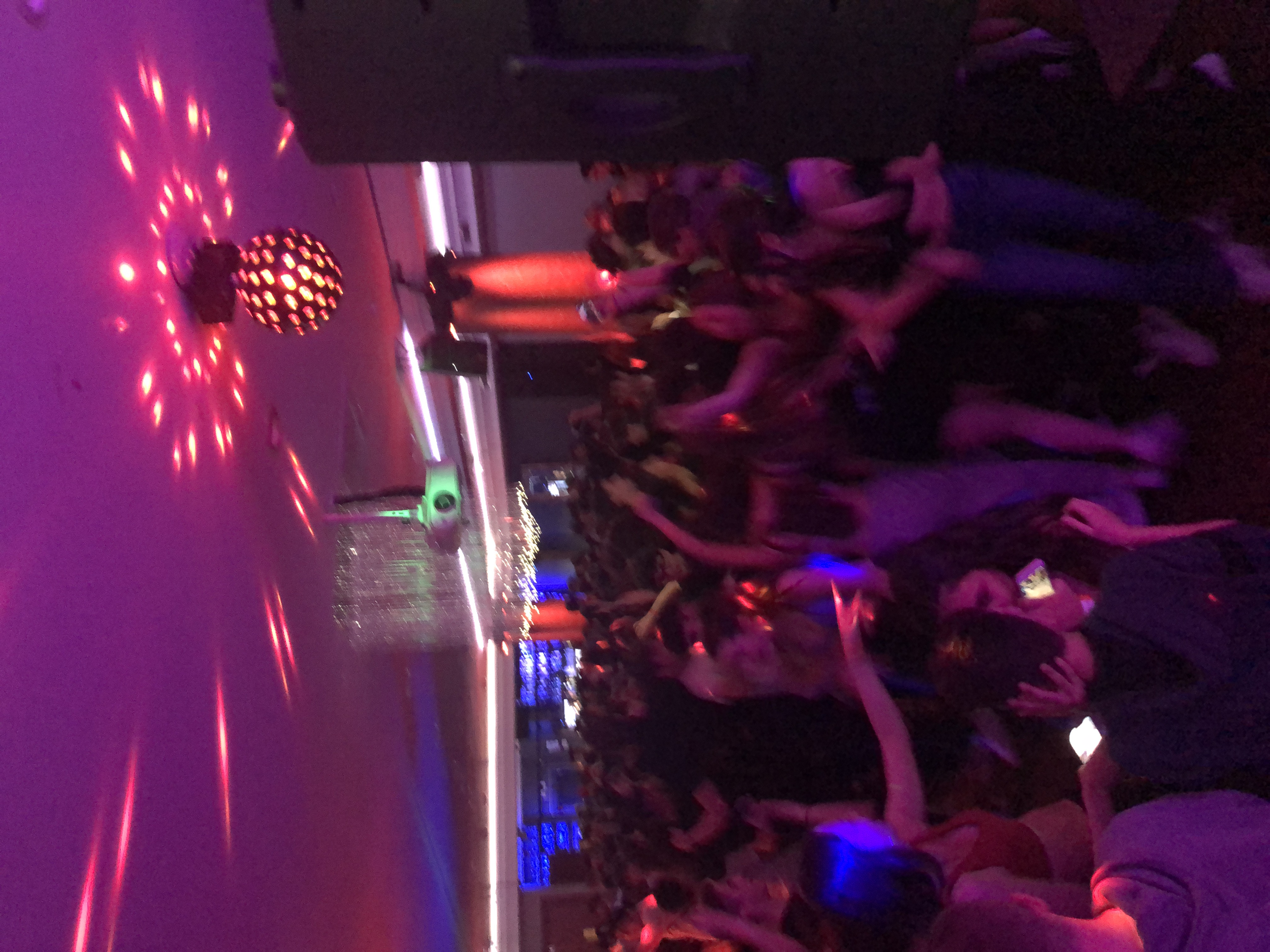 Vibrant nightlife event in Hagefen with lively crowd dancing under dynamic lighting.