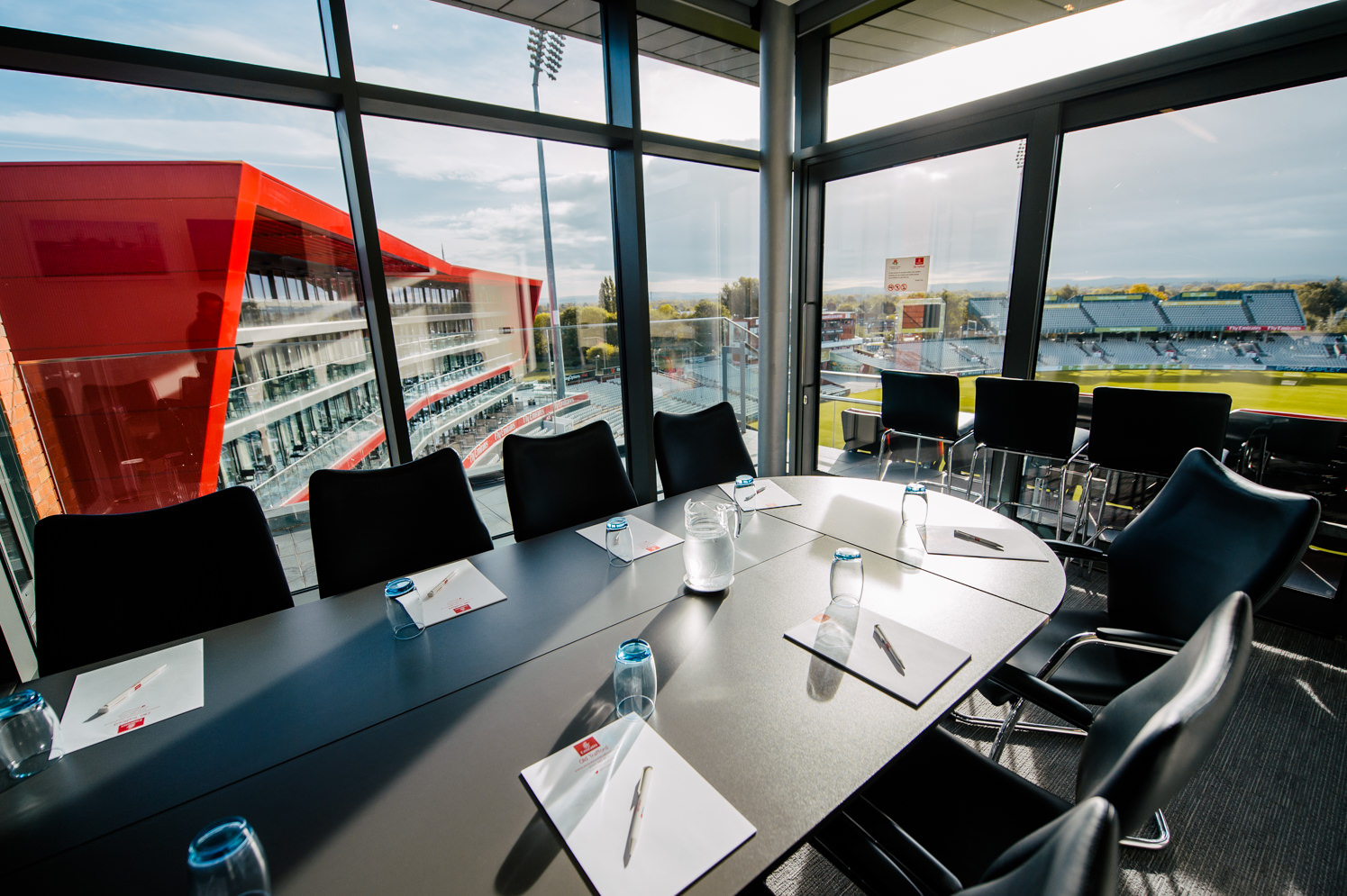 Modern meeting room with oval table at Emirates Old Trafford for corporate events.
