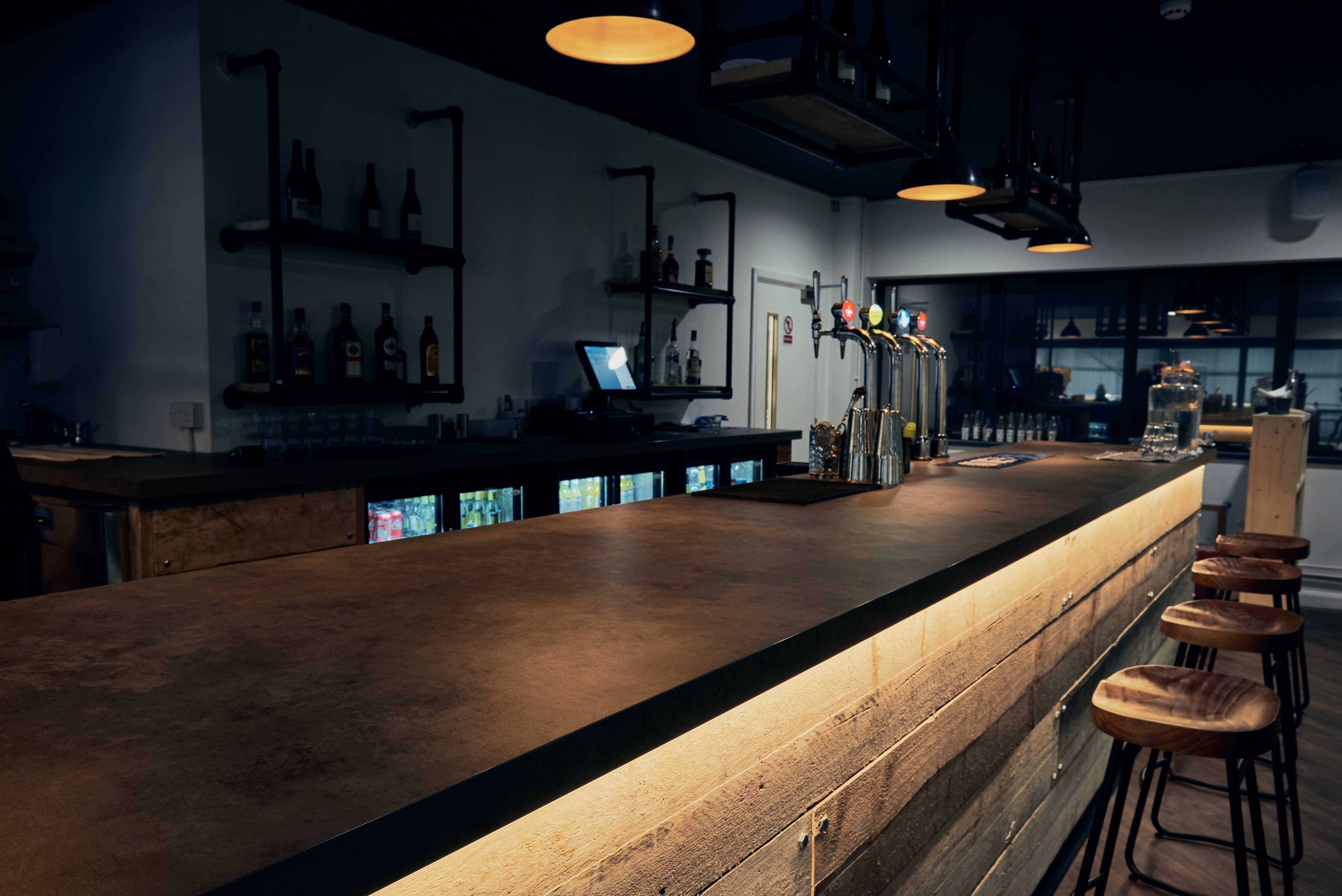 Modern bar setup with warm lighting for networking events at Graystone Manchester. - Banner