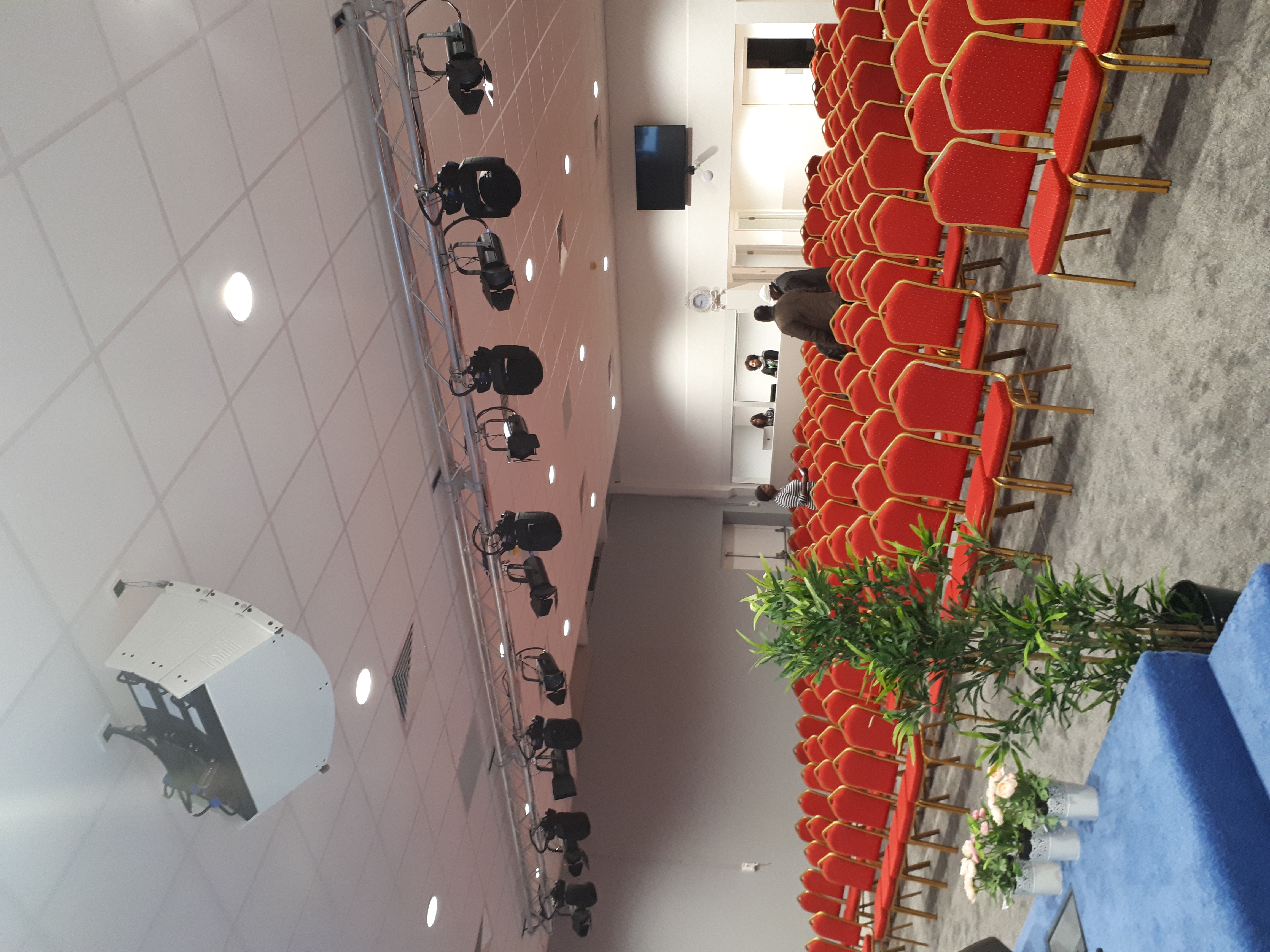 Business conference room with red chairs, ideal for seminars and presentations.