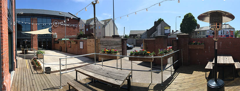 Outdoor event space at The Waiting Room, Tramshed Cardiff with string lights and planters.
