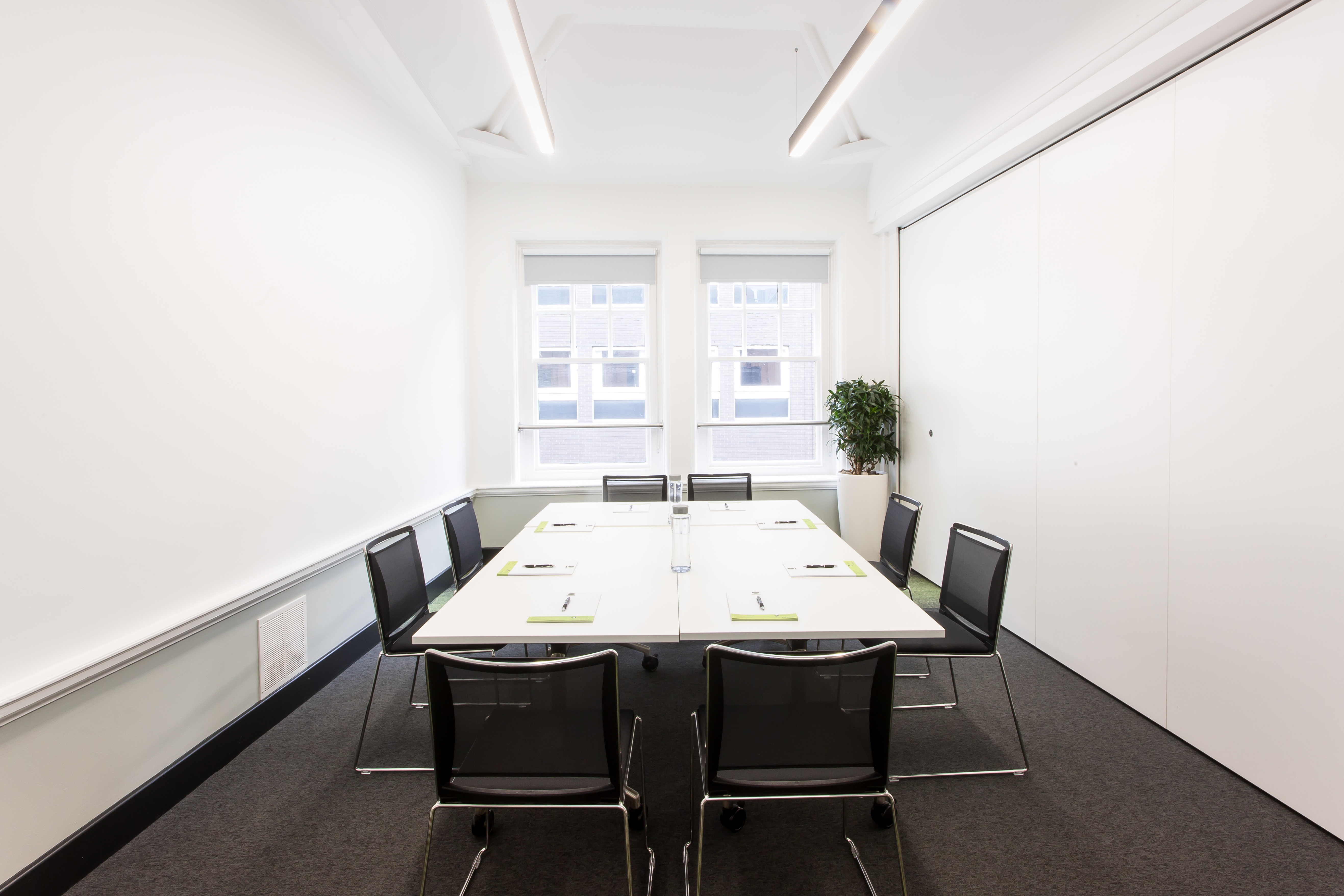 Modern minimalist meeting room with large table, ideal for brainstorming sessions.