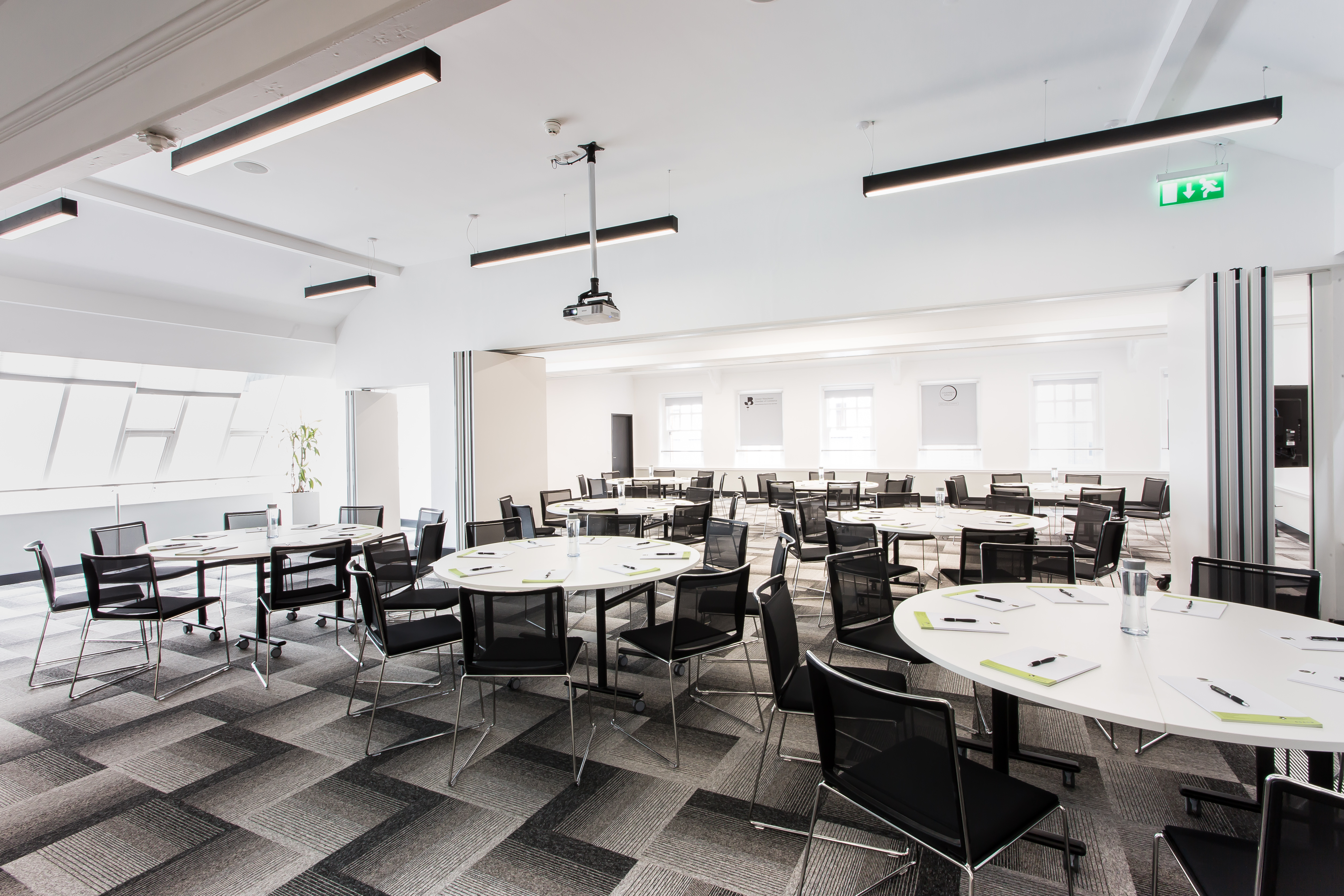 Modern meeting space with round tables, ideal for workshops and presentations.