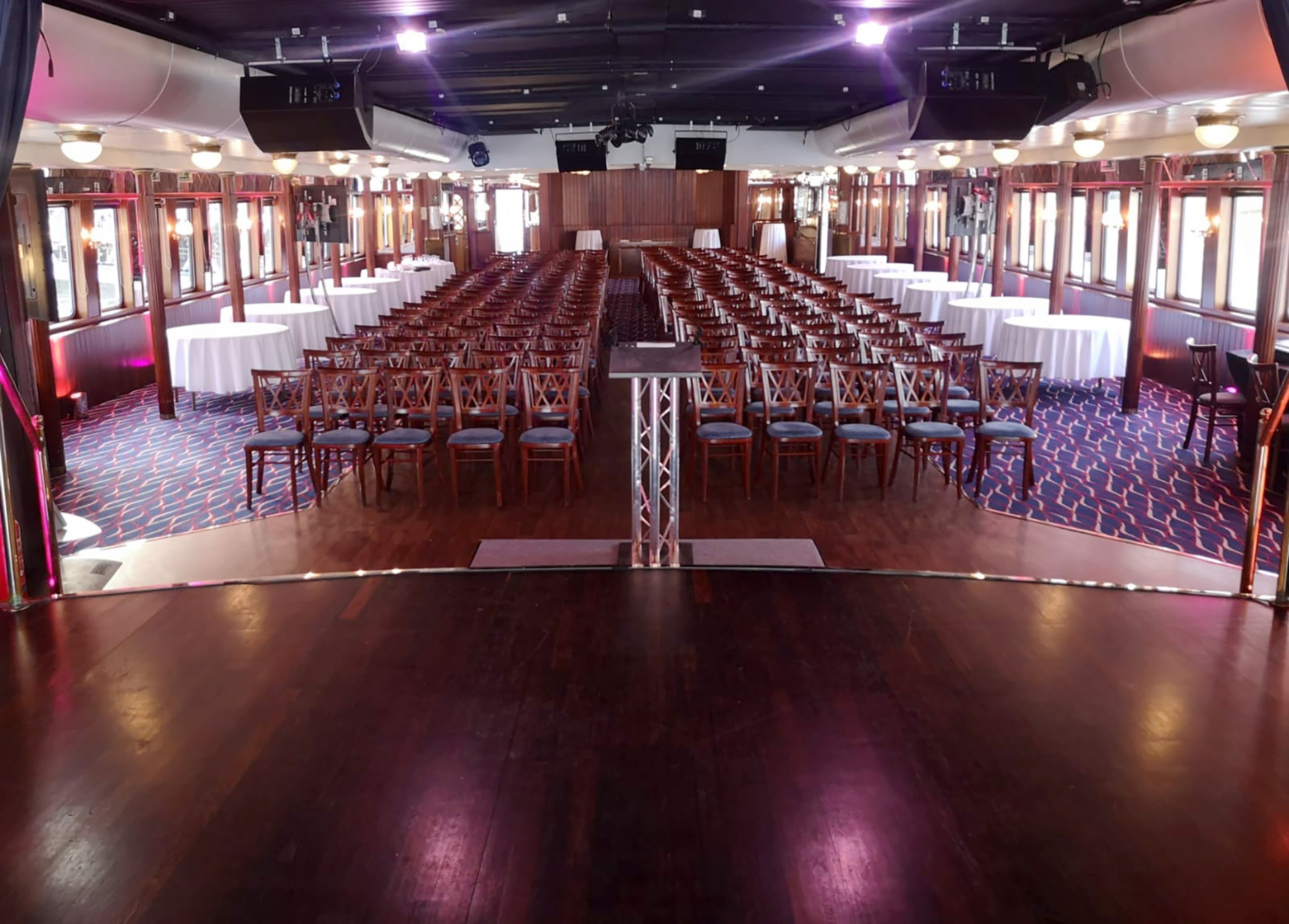 Event space in Dixie Queen with chairs and stage, ideal for conferences and banquets.