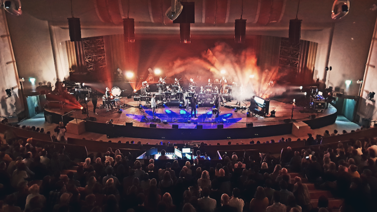 Vibrant live performance at EartH Theatre with dynamic stage and engaged audience. - Banner