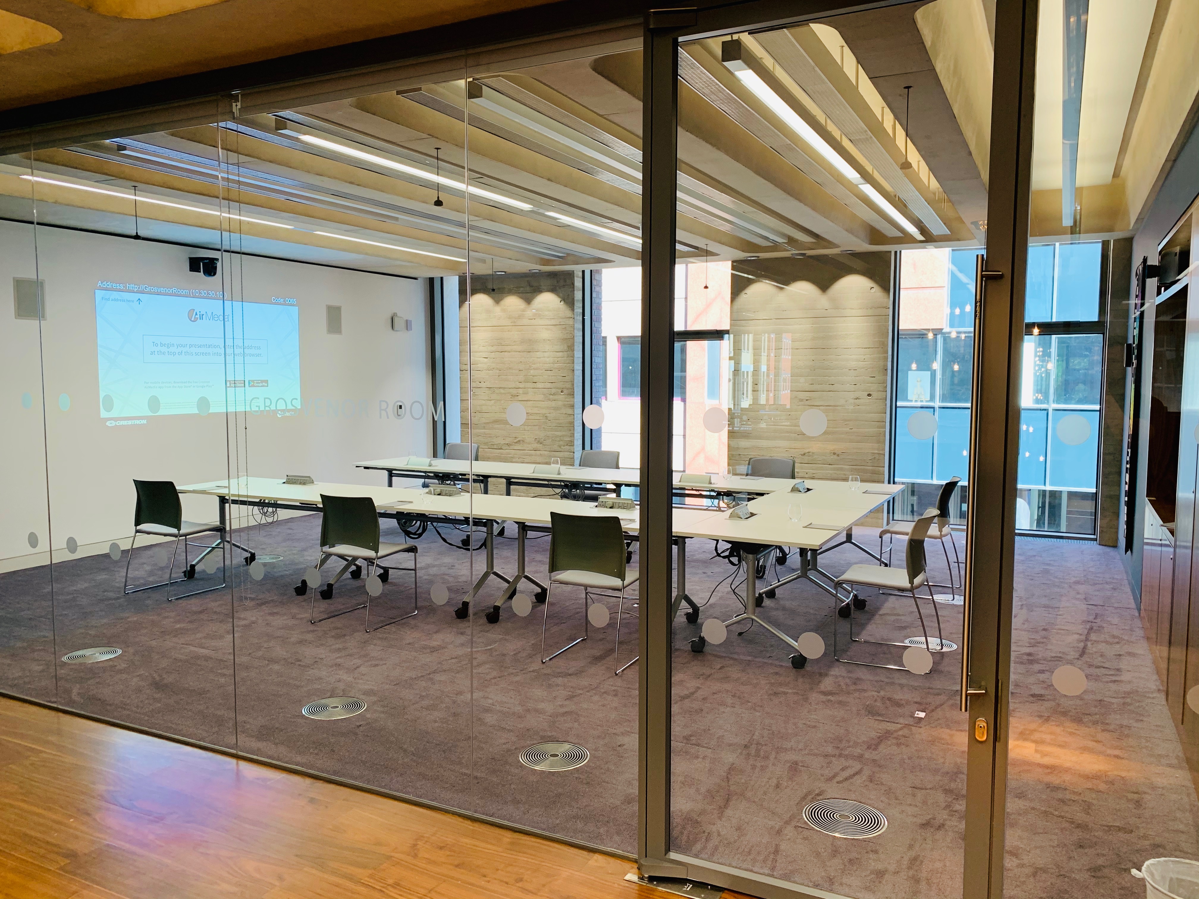 Modern meeting room with glass walls, ideal for collaborative events and presentations.