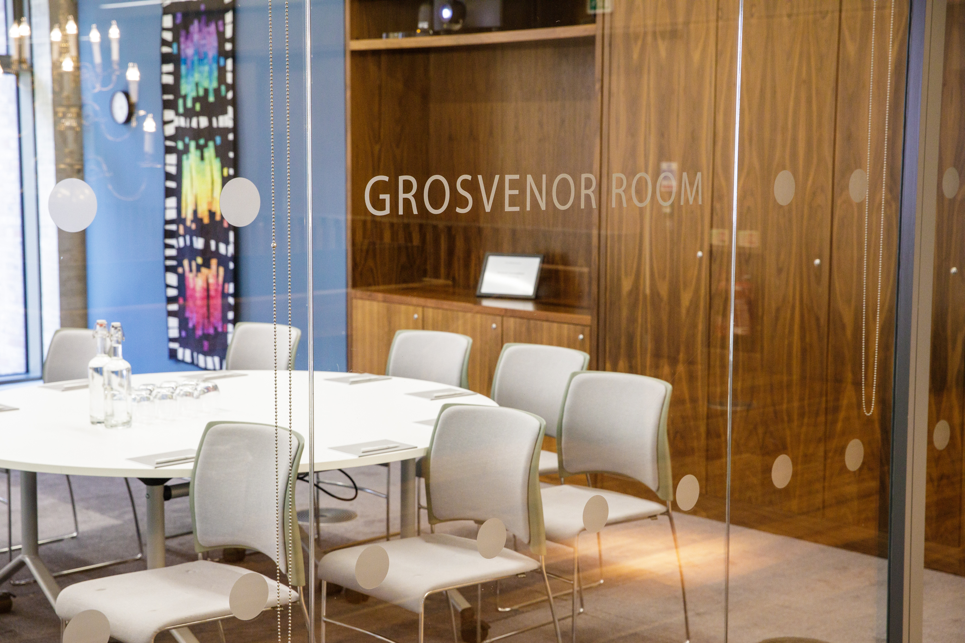 Grosvenor Room: modern meeting space with round table, ideal for events and gatherings.